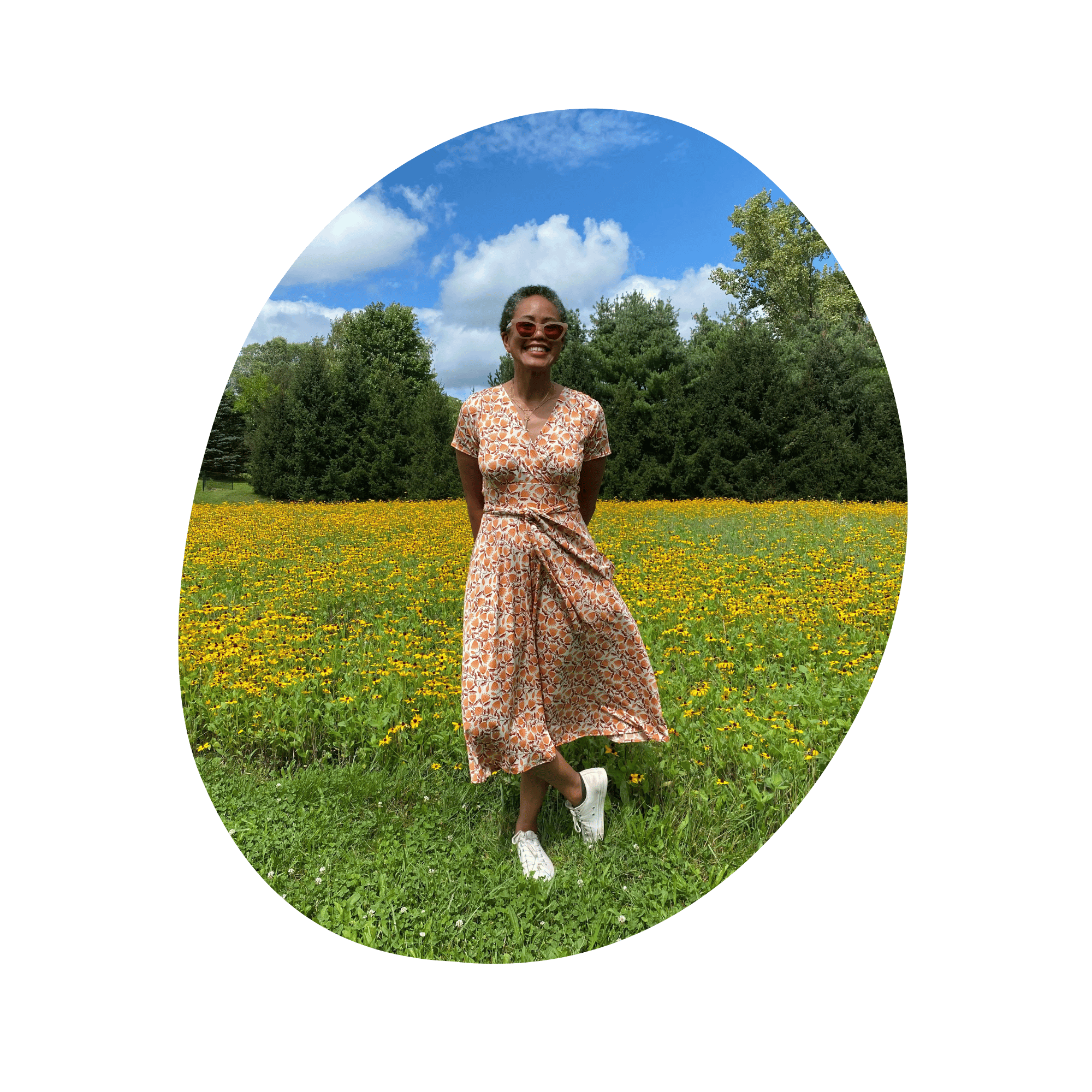 A smiling black woman stands in a field of yellow flowers .