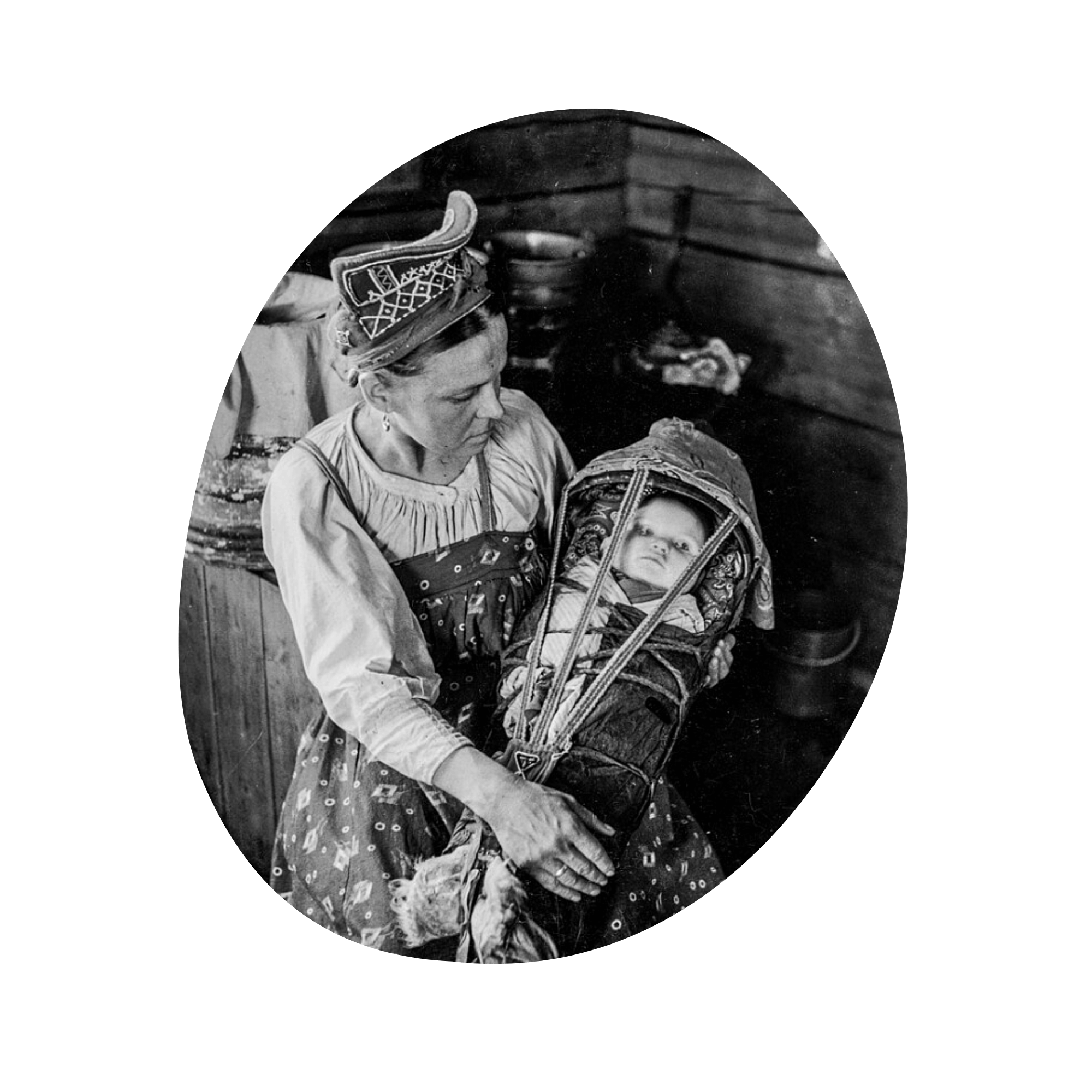 A black and white photo of a Sami mother in traditional clothing holding a baby swaddles in a cradleboard