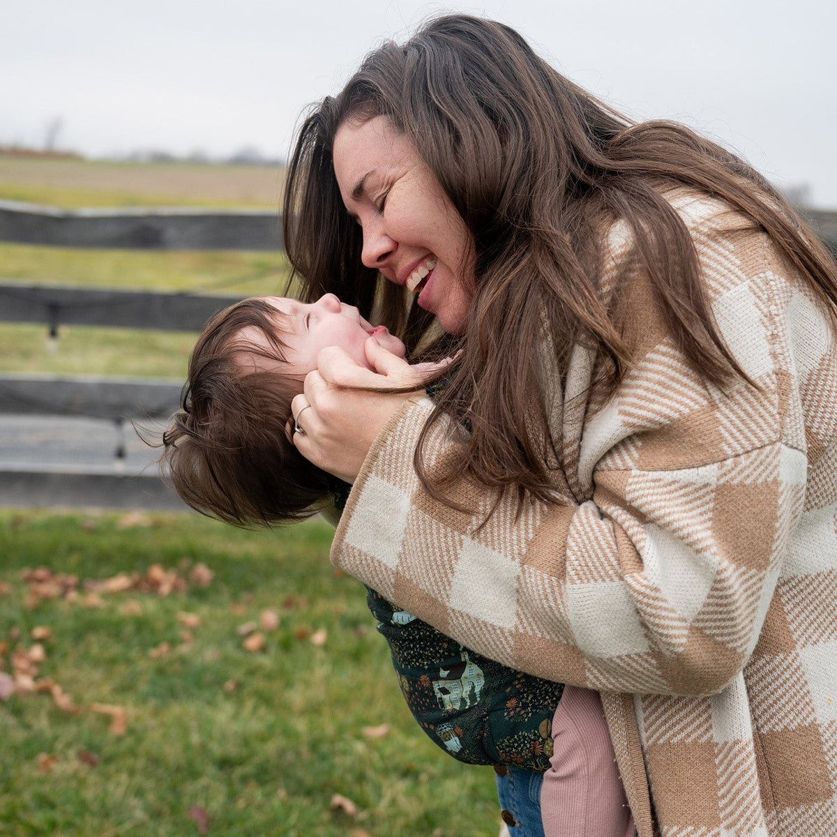 Mother babywearing her baby in a soft structured carrier bonding