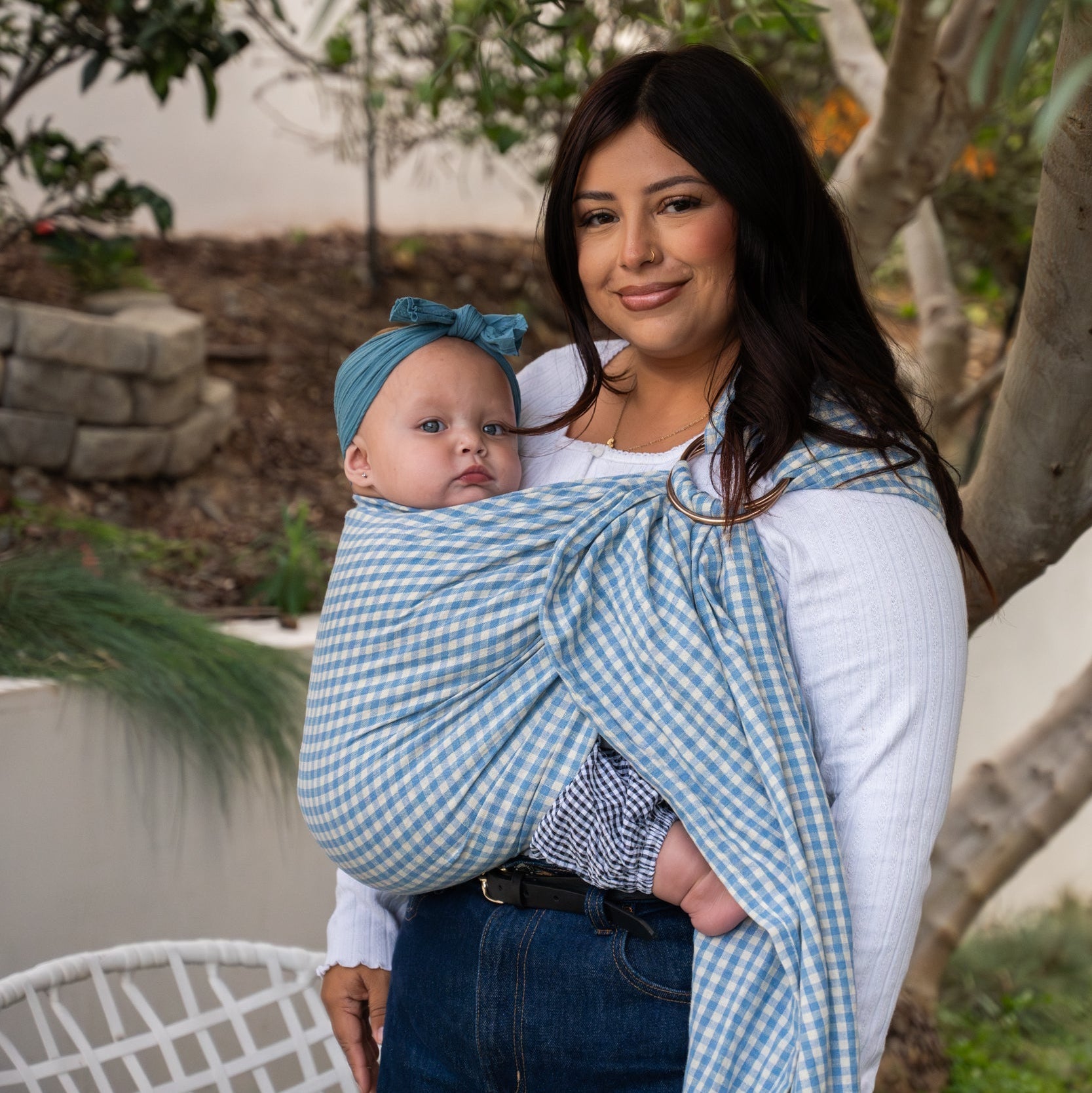 Woman holding her baby in a ring sling fabric.