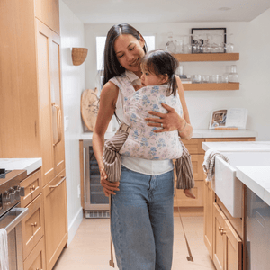 A straight size BIPOC woman wears her toddler on her front in a hope&plum Blush Kid Lark