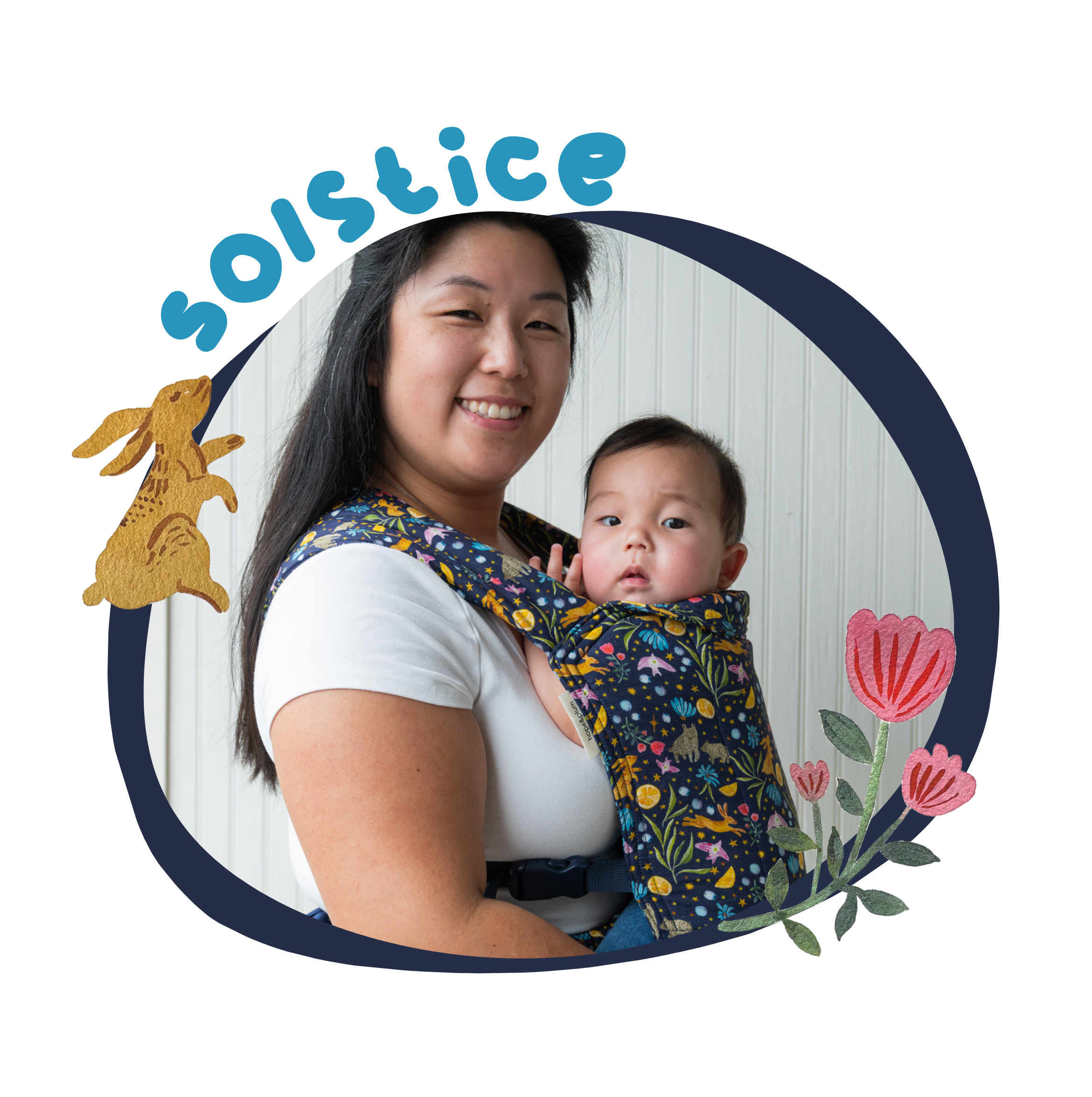 An asian woman wears a midnight blue Lark baby carrier with a multicolored print made up of watercolor paintings of stars, bunnies, bears, flowers, foliage, and oranges. She is carrying her baby and they both look at the camera. The image is bordered by the same midnight blue, with the heading 'Solstice' and a close up of the bunny rabbit and tulip paintings.