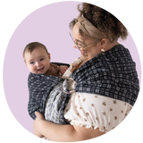 Plus size mother wearing a black and white plus size baby carrier with her smiling infant