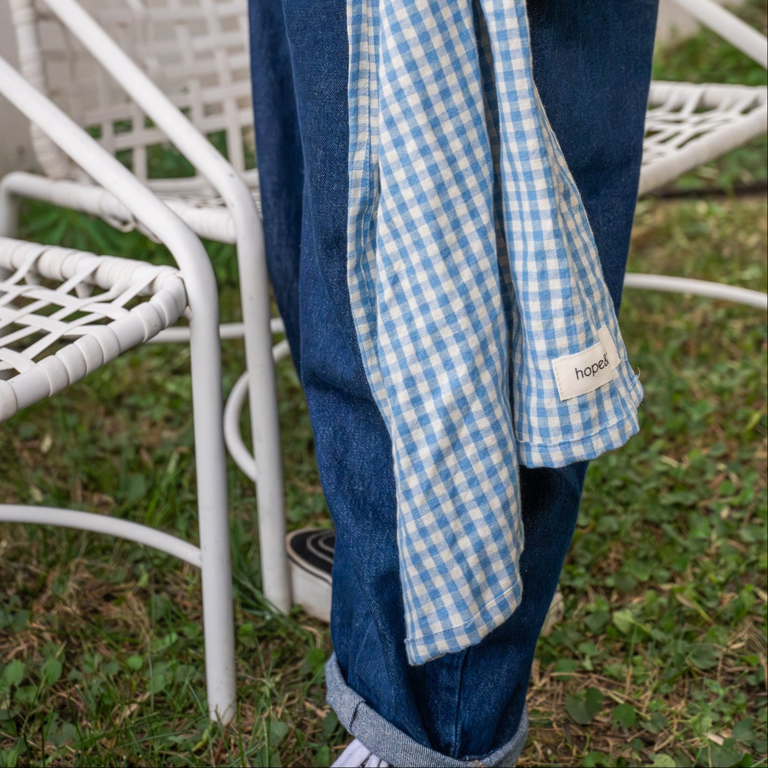 Tail of blue and white gingham ring sling against pants leg