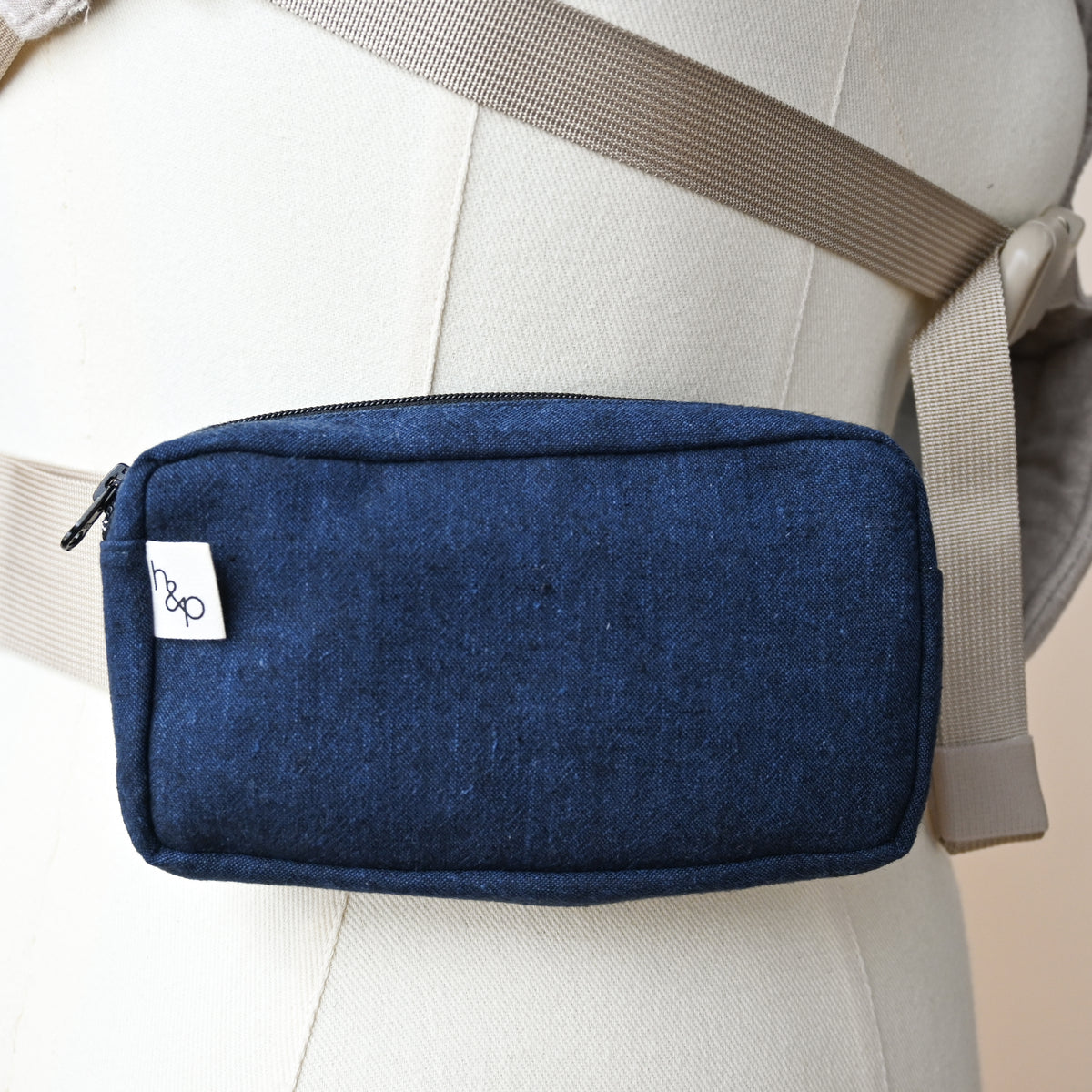Carrier Pocket in Caspian, a zip pouch on a carrier waistband shown on a dress form, deep indigo woven chambray with the look of dark denim.