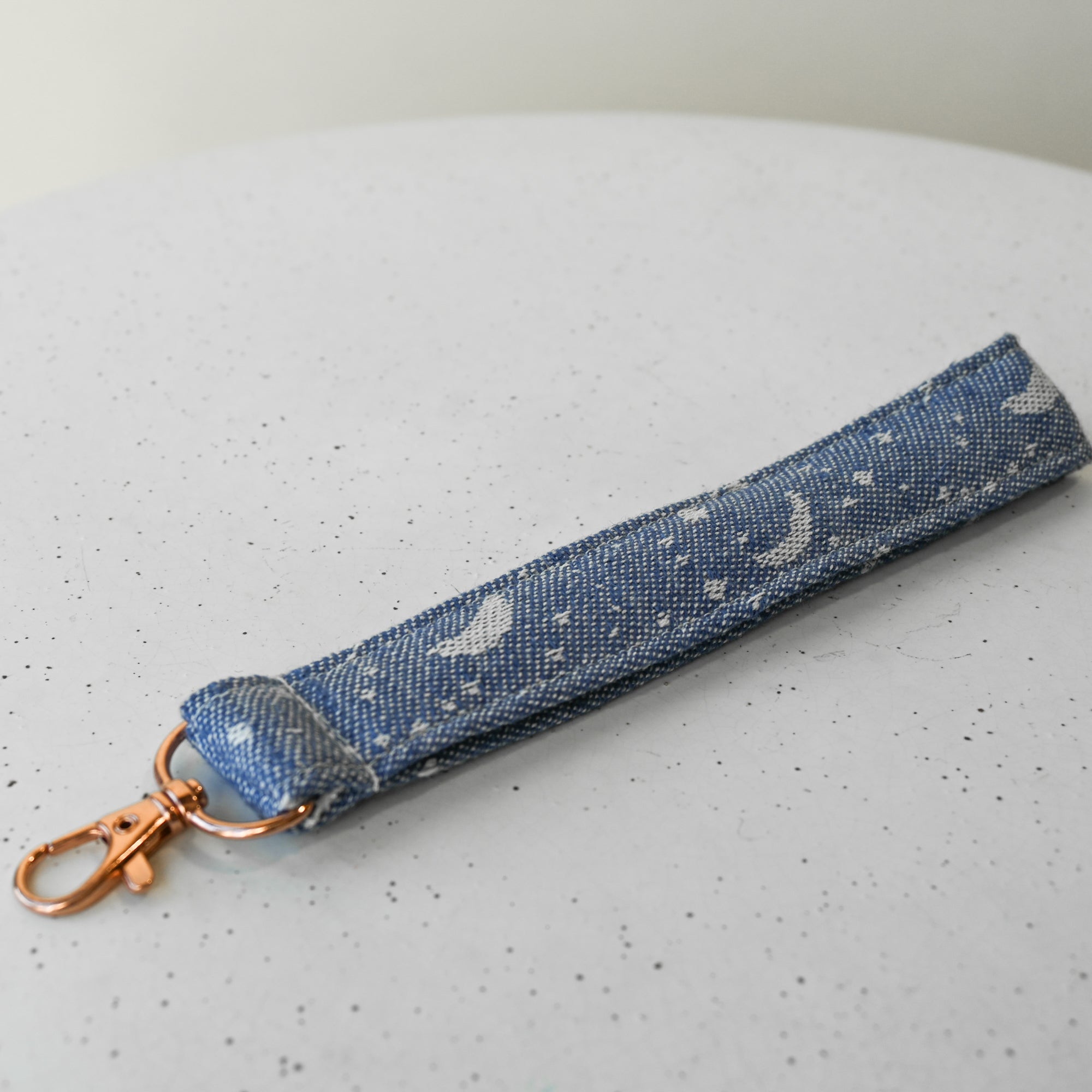 Blue celestial print keychain with white patterns on a white background
