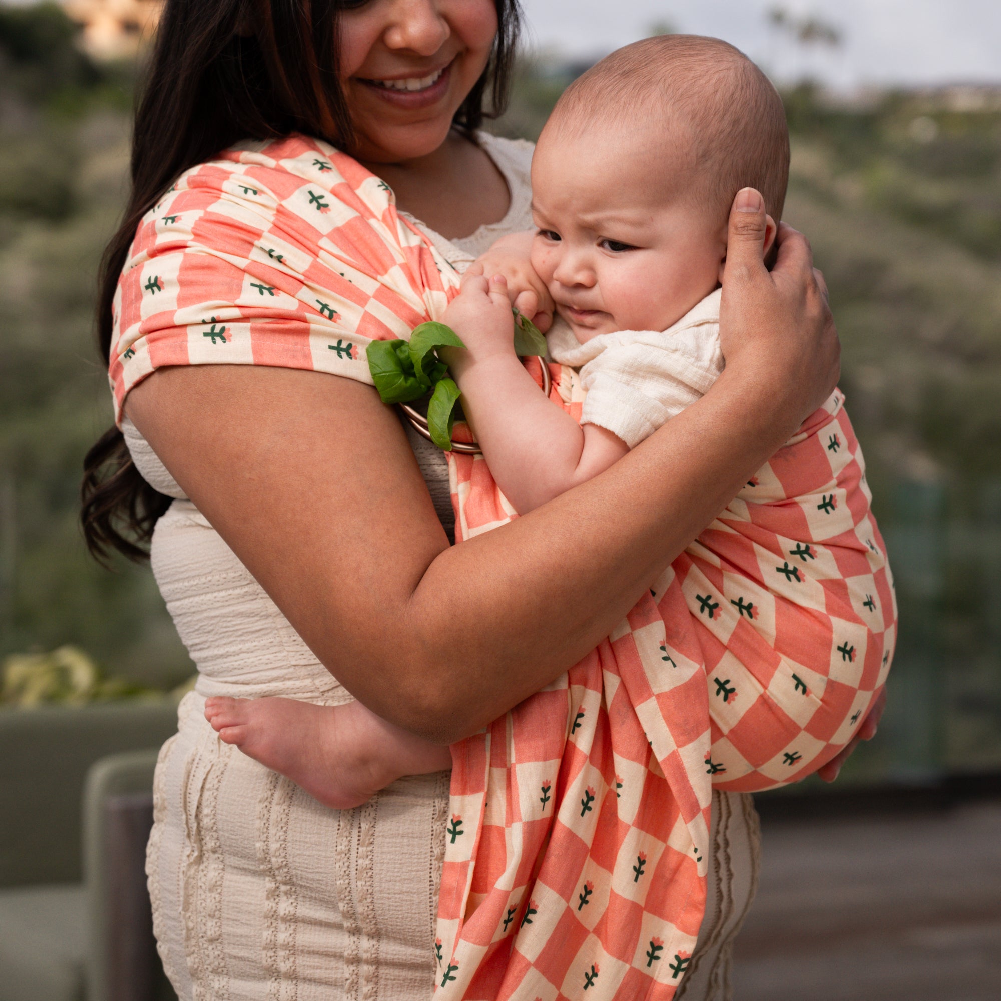 hope&plum Darling ring sling in coral checkerboard print worn front carry with newborn