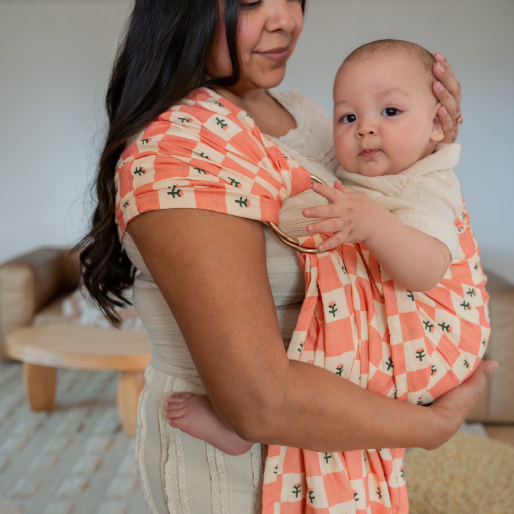 hope&plum Darling ring sling with champagne rings in coral checkerboard print worn front carry with newborn