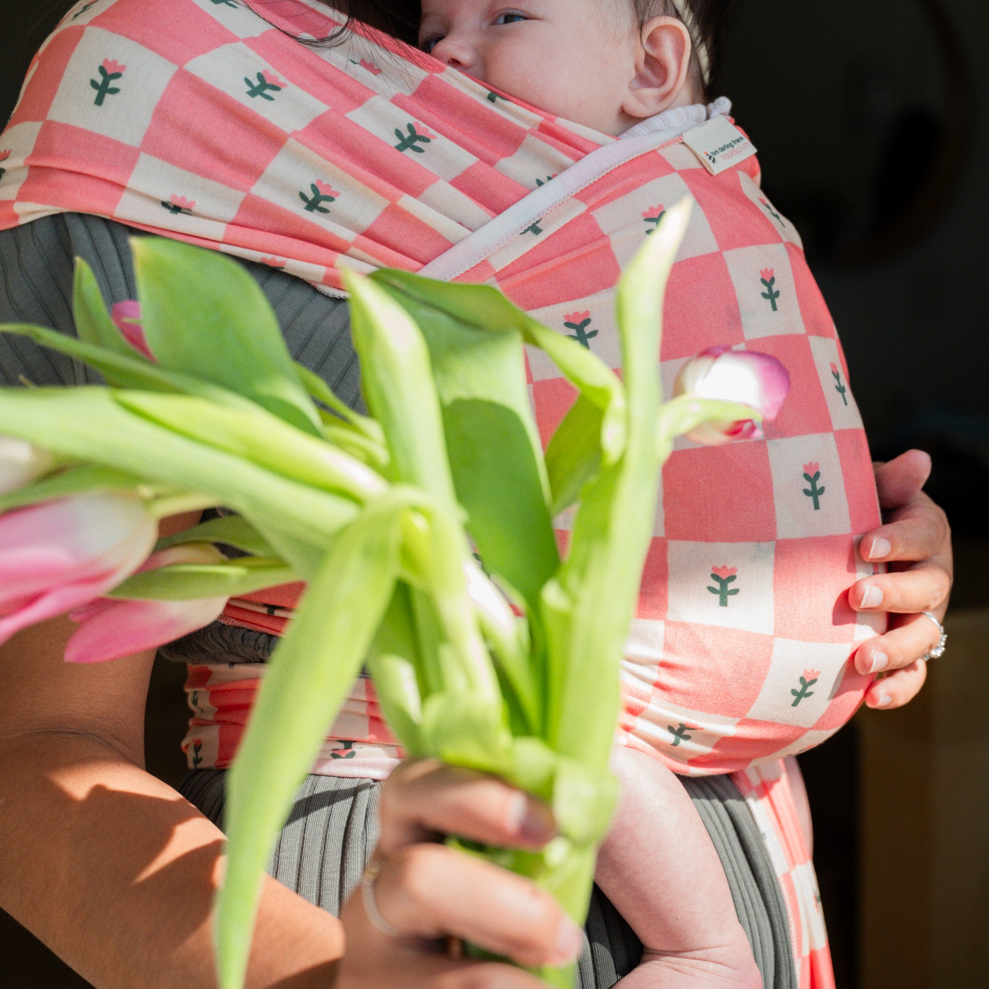 hope&plum Darling baby wrap carrier coral checkerboard with tulips in front carry position