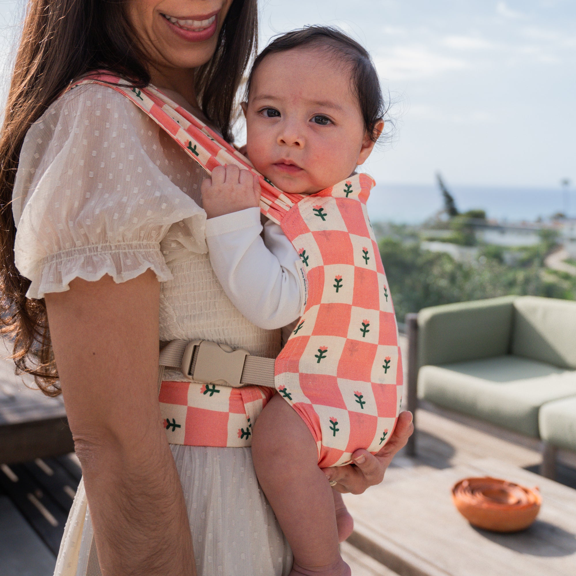 hope&plum Darling Sprout newborn buckle baby carrier coral checkerboard with tulips in front carry position
