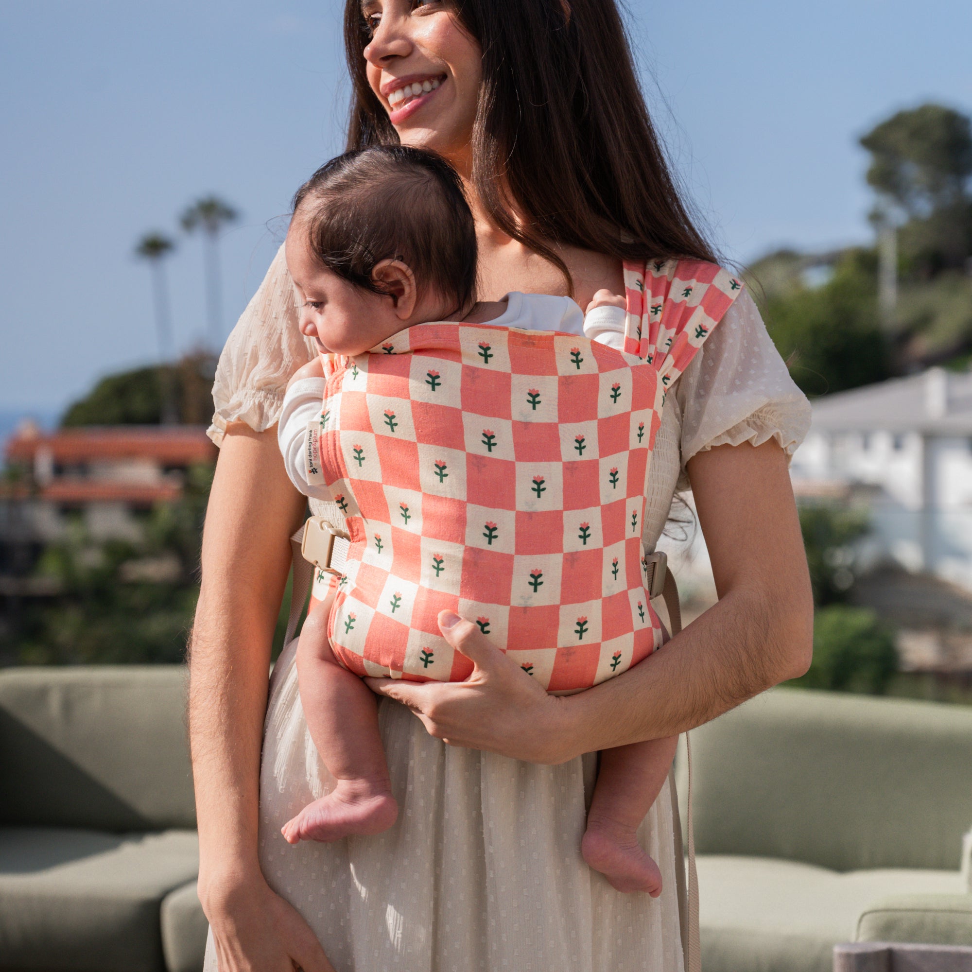 hope&plum Darling Sprout newborn buckle baby carrier coral checkerboard with tulips in front carry position