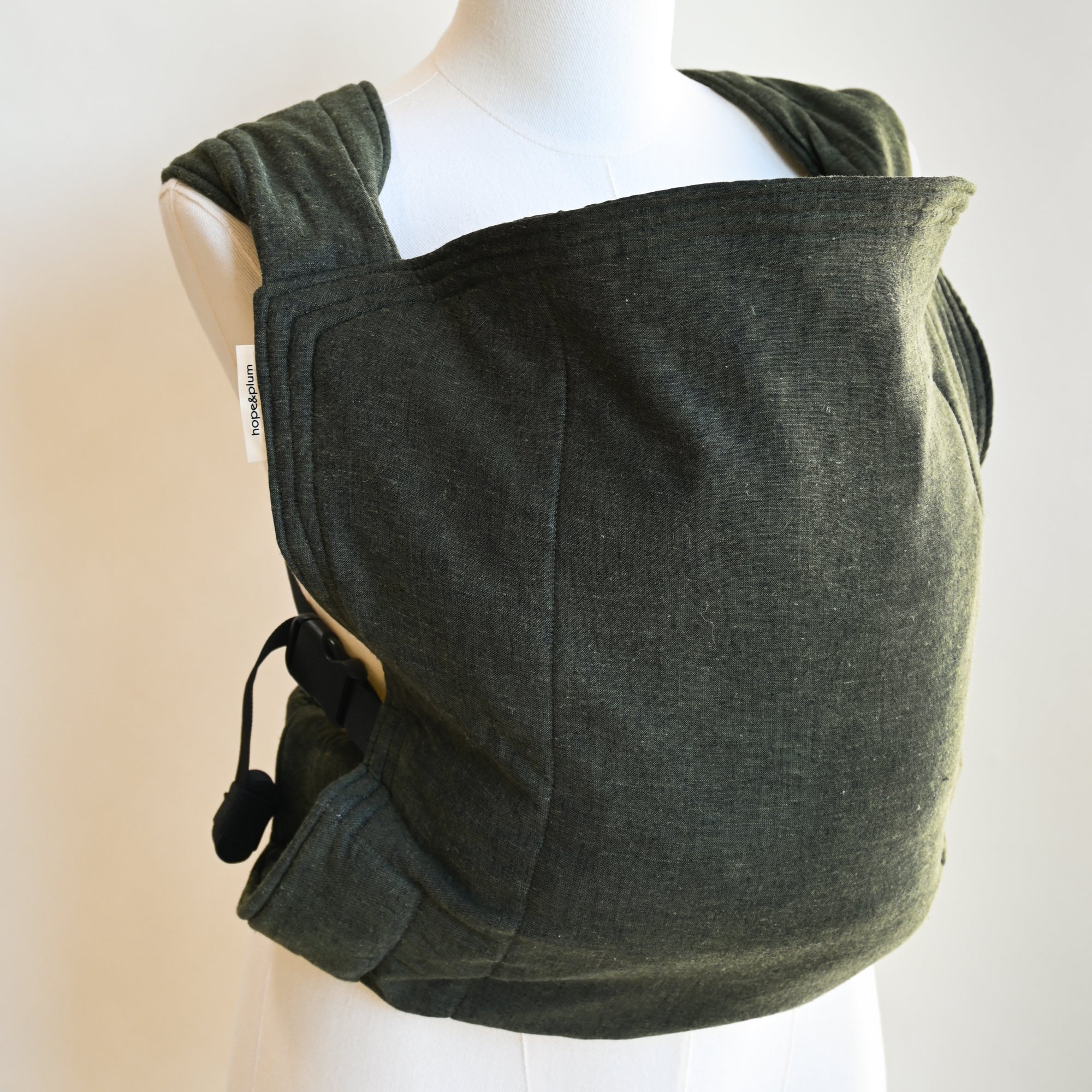 Green heathered child carrier on a mannequin