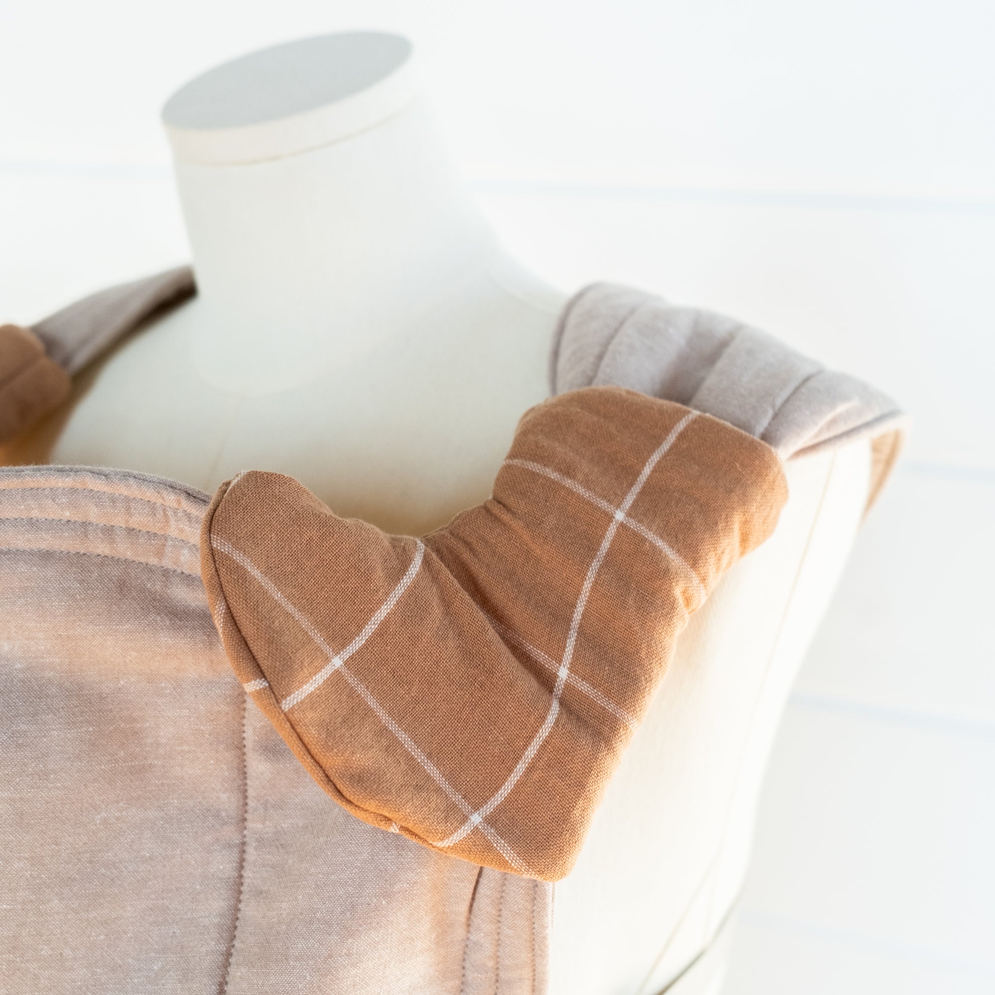brown grid pattern drool pads on a mannequin with a white background