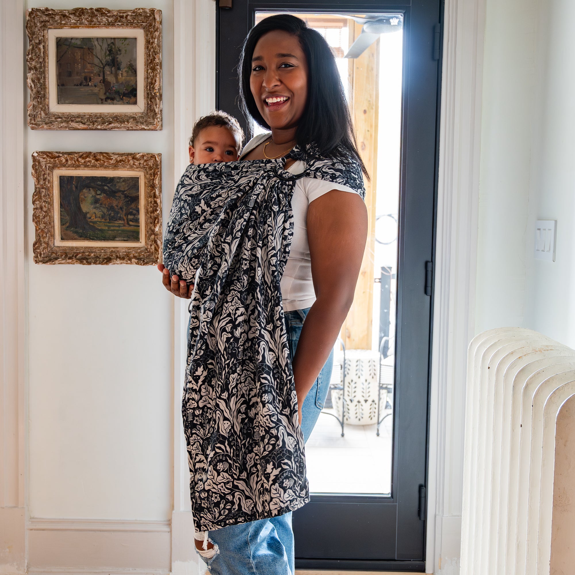 Woman holding a baby in a sling at home