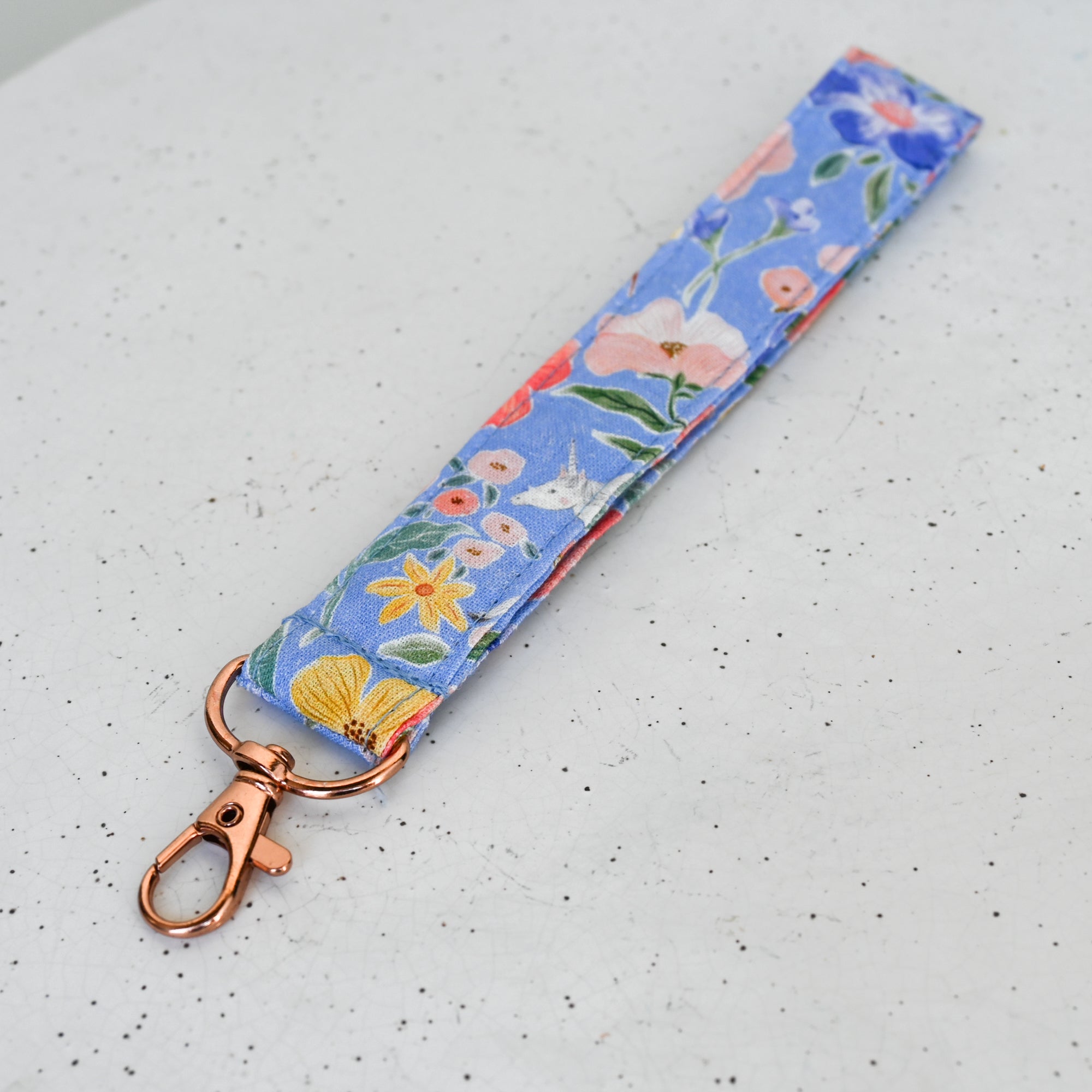 Floral patterned keychain with rose gold clasp on a light gray background