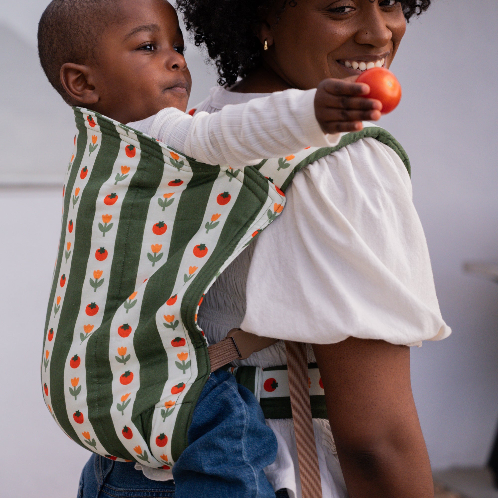 hope&plum Medley Kid Lark buckle toddler carrier olive green stripe with tomatoes and tulips in back carry position