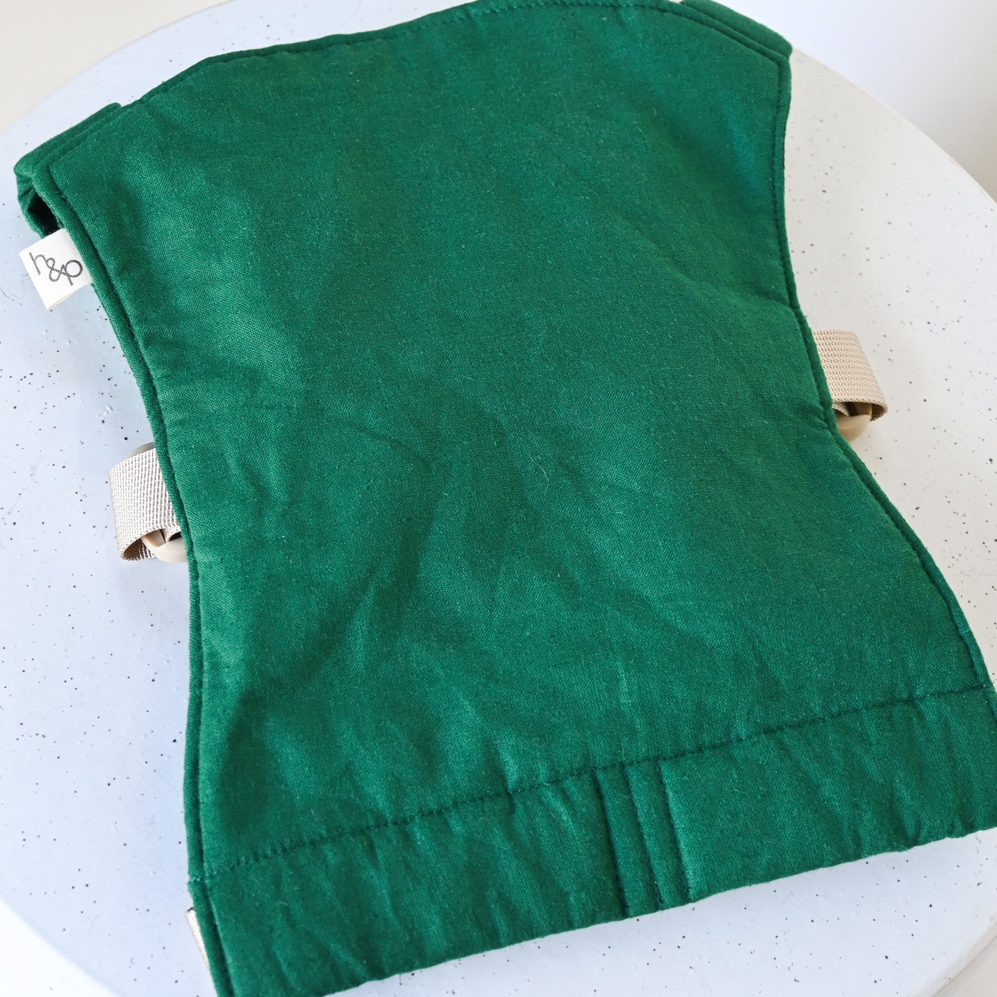 Green baby doll carrier on a white background