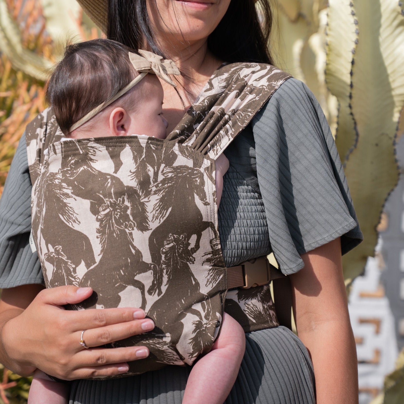 Sprout Newborn Carrier in Rodeo β close-up of a newborn's head resting against the mustang print body panel.