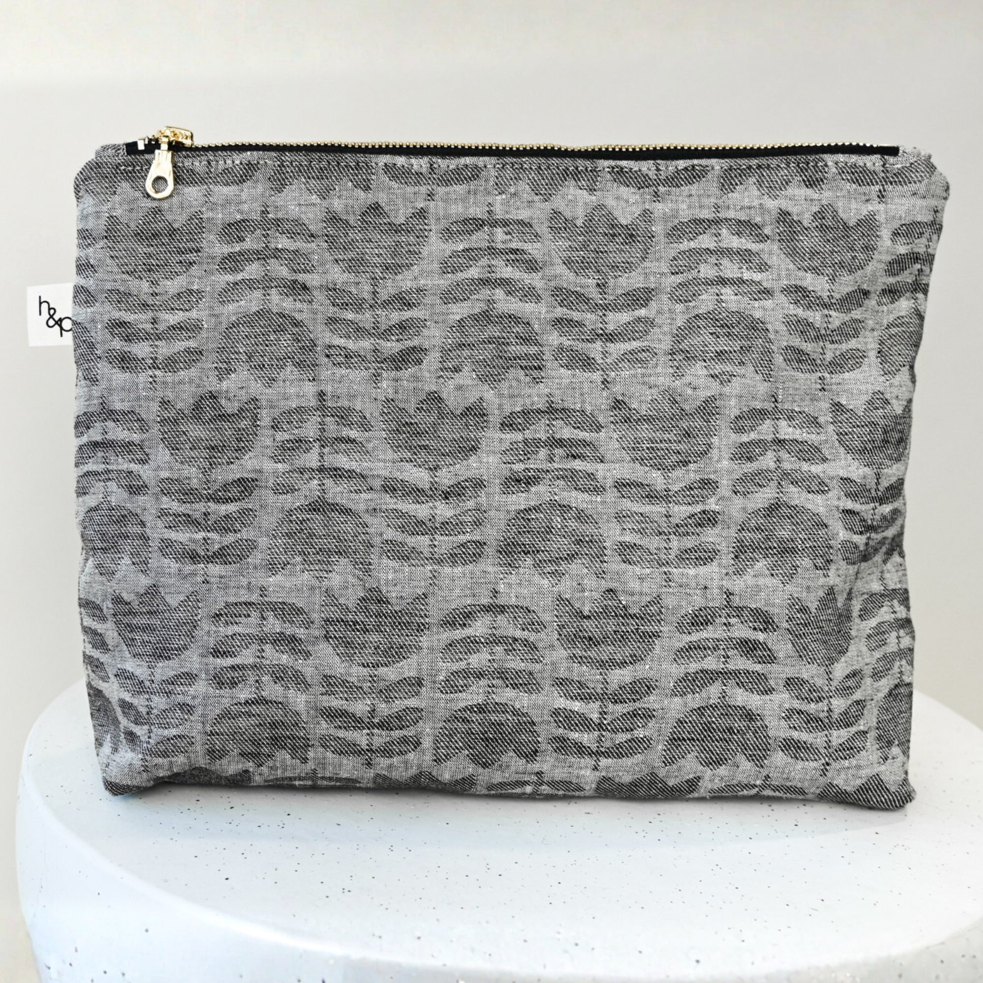 Gray tulip patterned pouch on a white pedestal