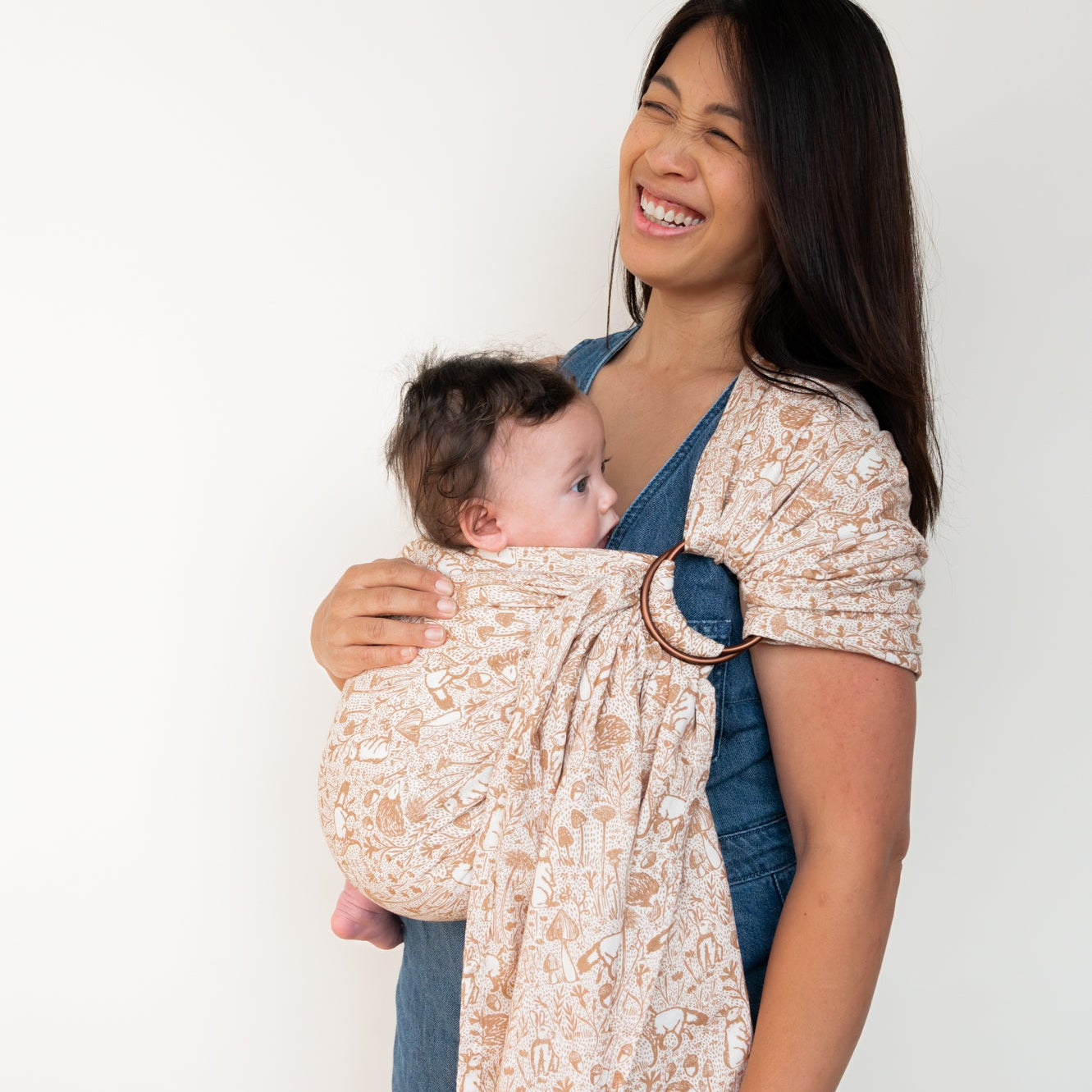 Woman wearing baby in woodland creature ring sling