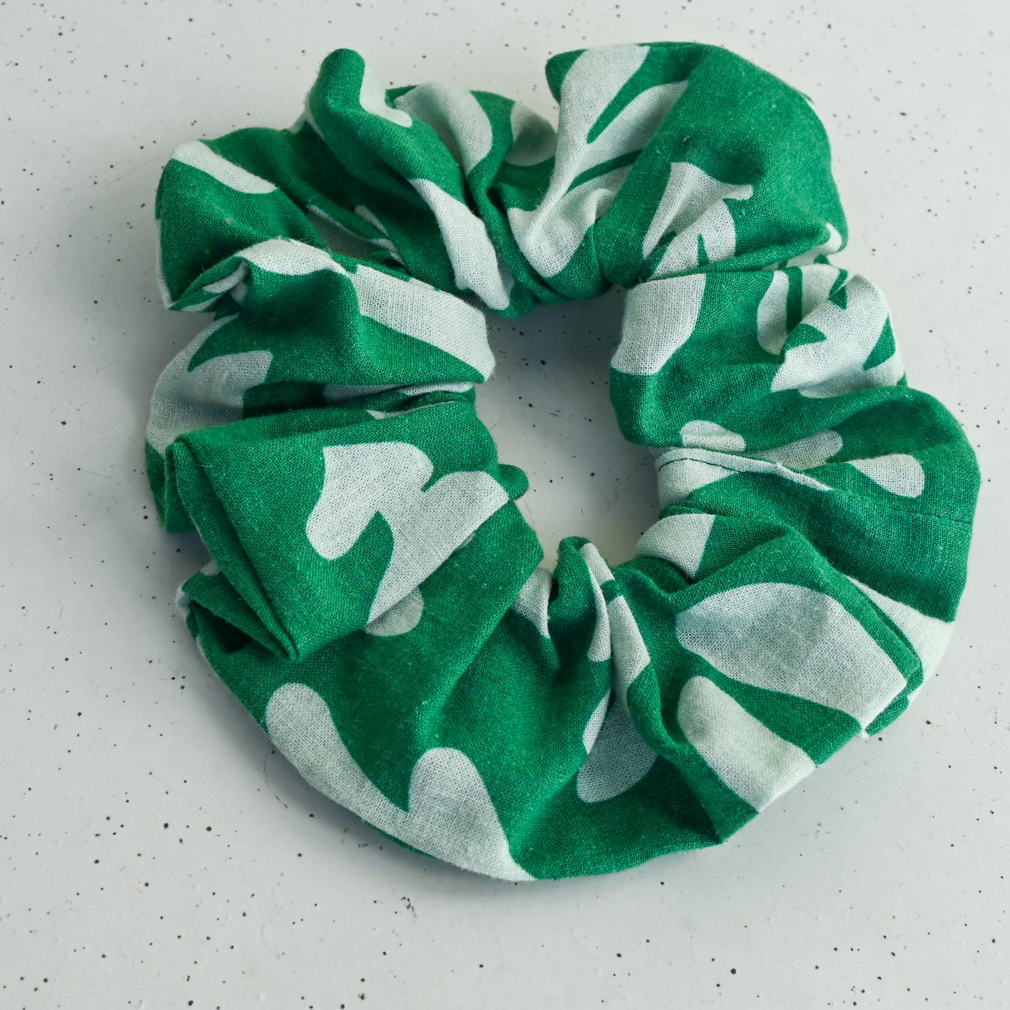 Green and white patterned scrunchie on a white background