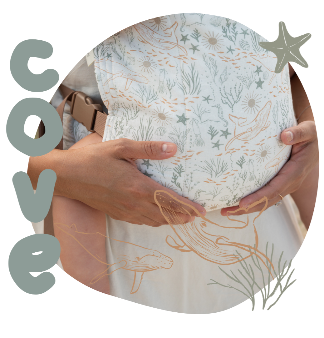 Mother holding child with ocean-themed baby carrier, 'Cove' brand visible
