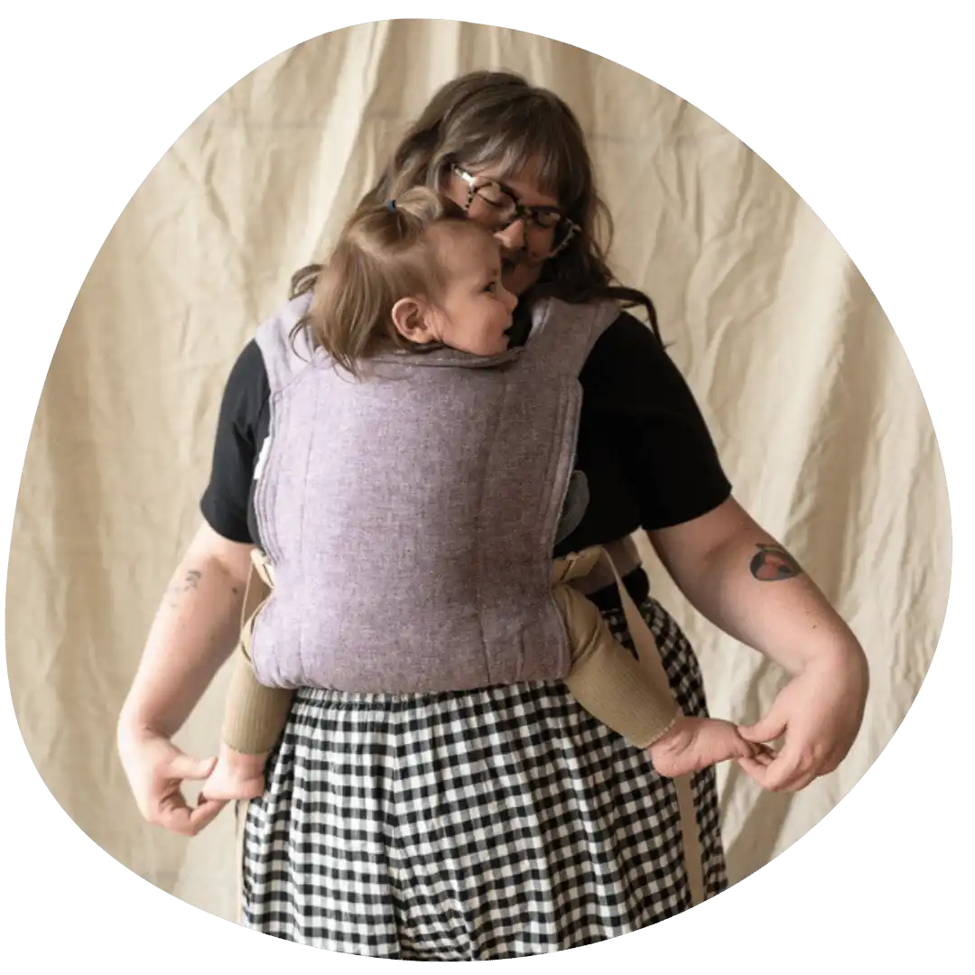 Woman carrying baby in carrier.