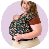 A plus size mother wearing her newborn in a dark moth floral plus-size baby carrier wrap