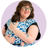 Plus size mother wearing her newborn in a matisse print meh dai plus size baby carrier