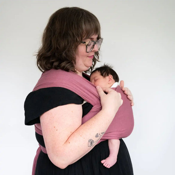 Woman holding a baby in a wrap.