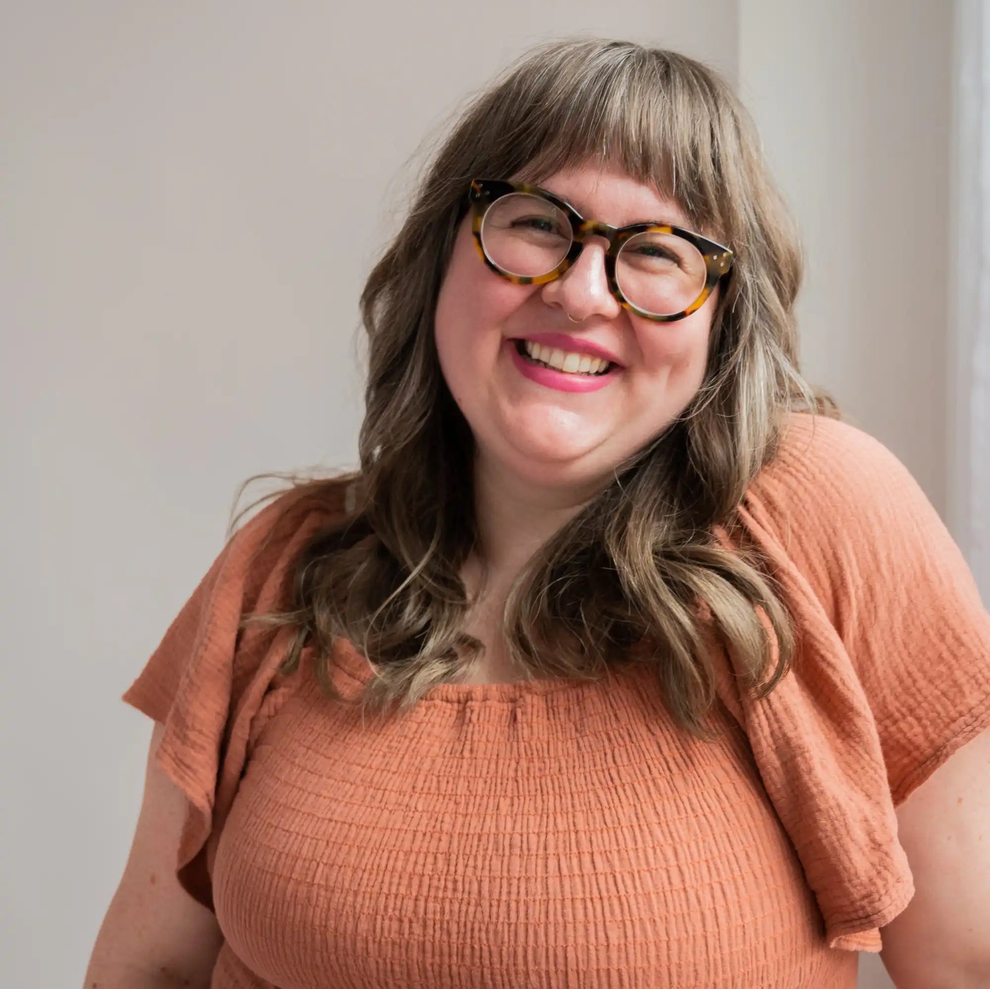 Smiling woman with glasses.