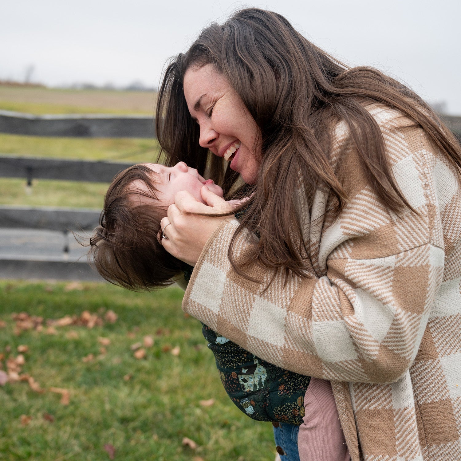 Mother babywearing her baby in a soft structured carrier bonding