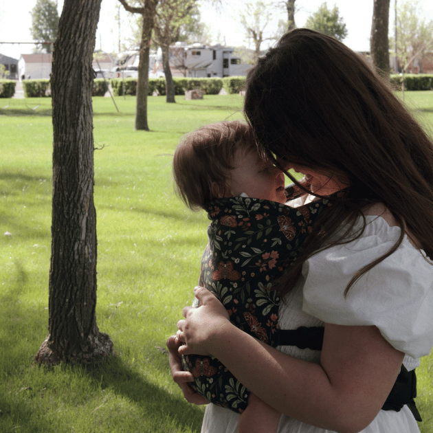 a mom snuggling forward to forward with her baby in a hope&plum night garden lark baby carrier