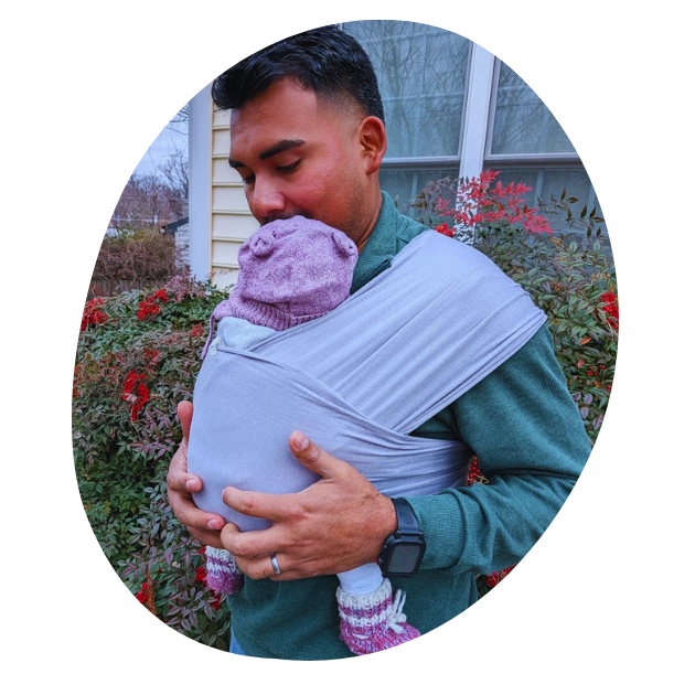 A photo of a diverse male caregivers wearing their newborn in a stretchy hope&plum newborn carrier