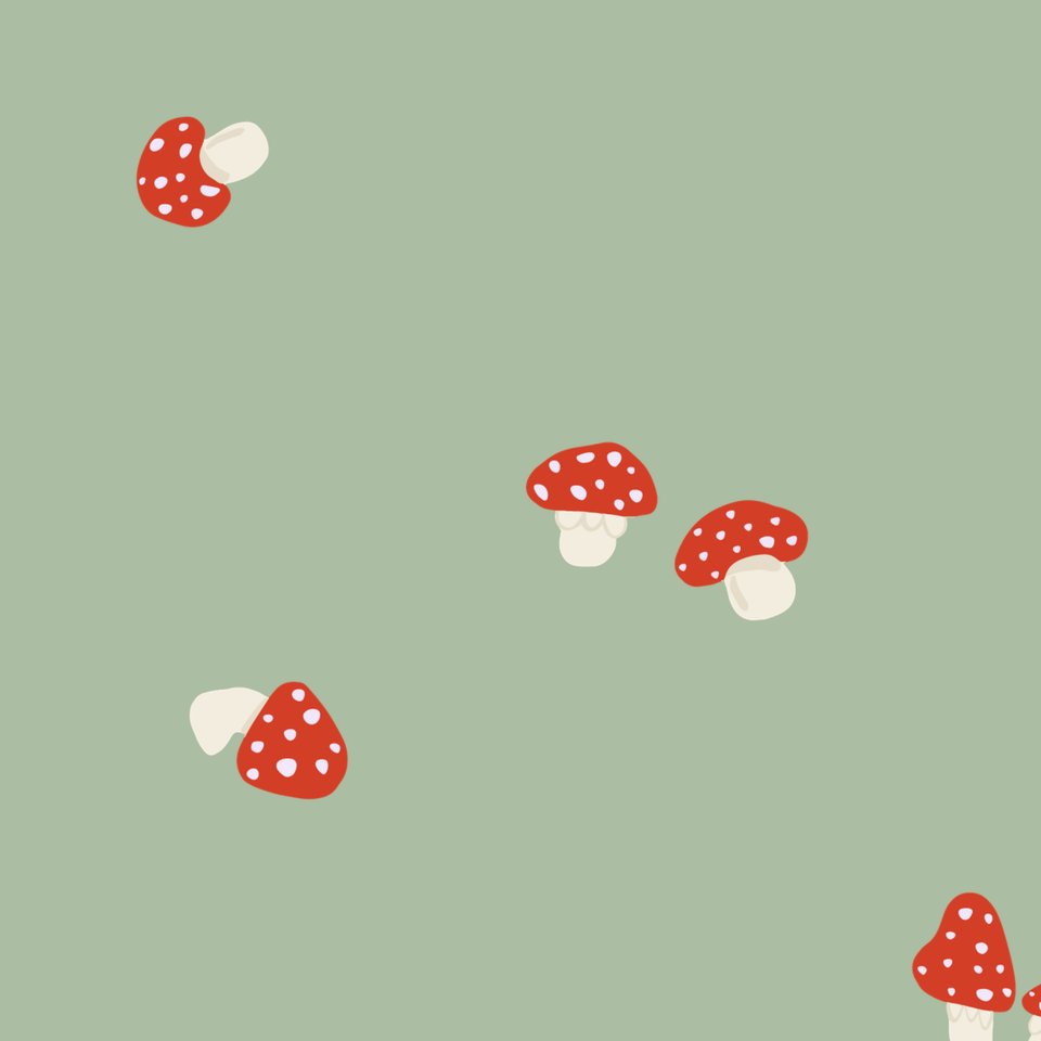 Embroidered fly agaric mushrooms in red and white on a palm-green chambray background