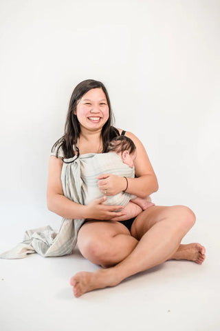 Mother baby wearing her infant in a ring sling