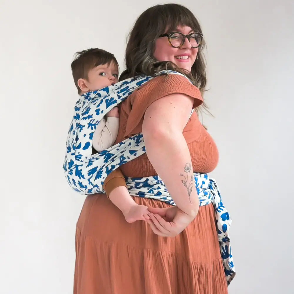 Plus size mother wearing baby on her back in meh dai baby carrier. 