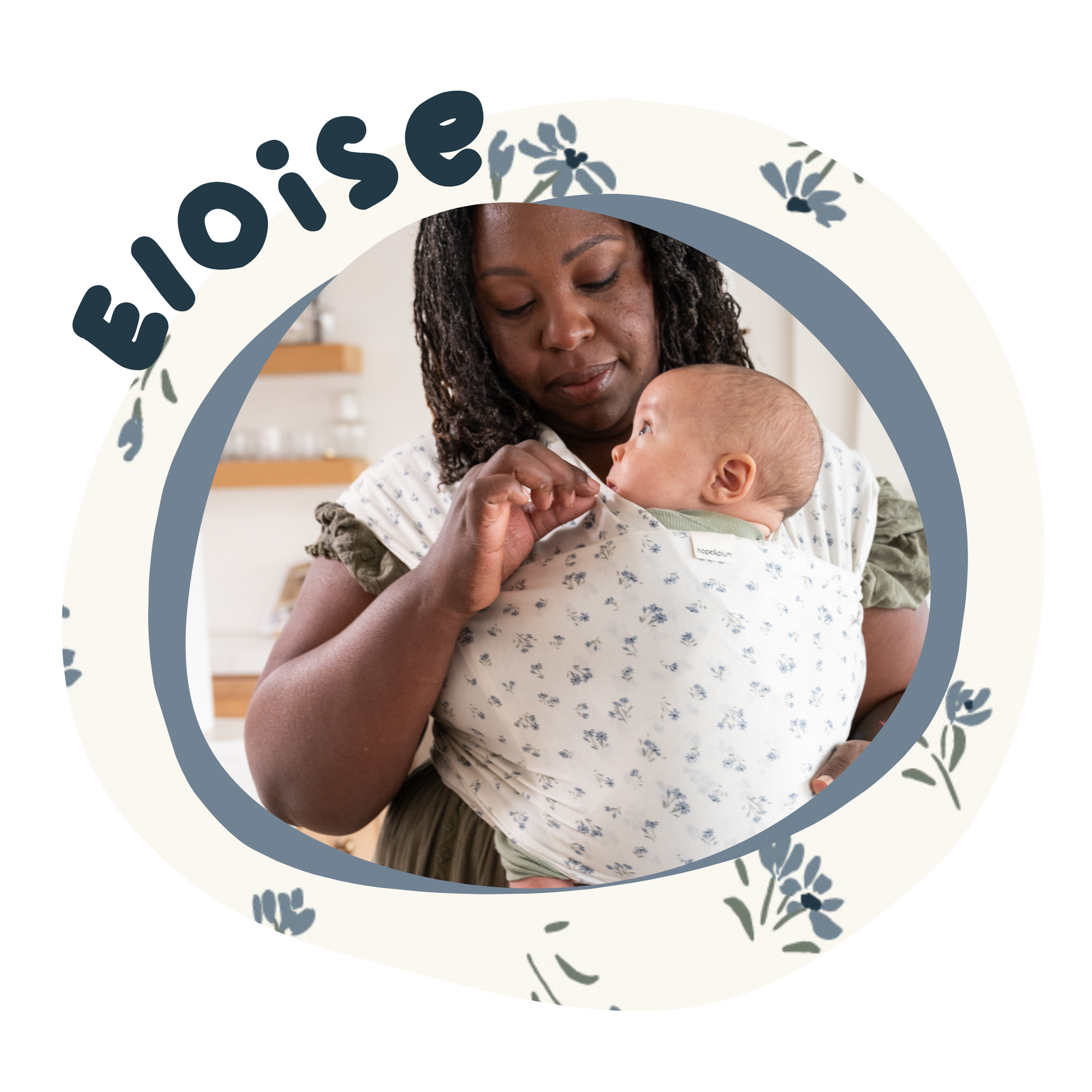 a black woman carries a baby in a stretchy wrap. The wrap is white with dainty blue flowers on it.
