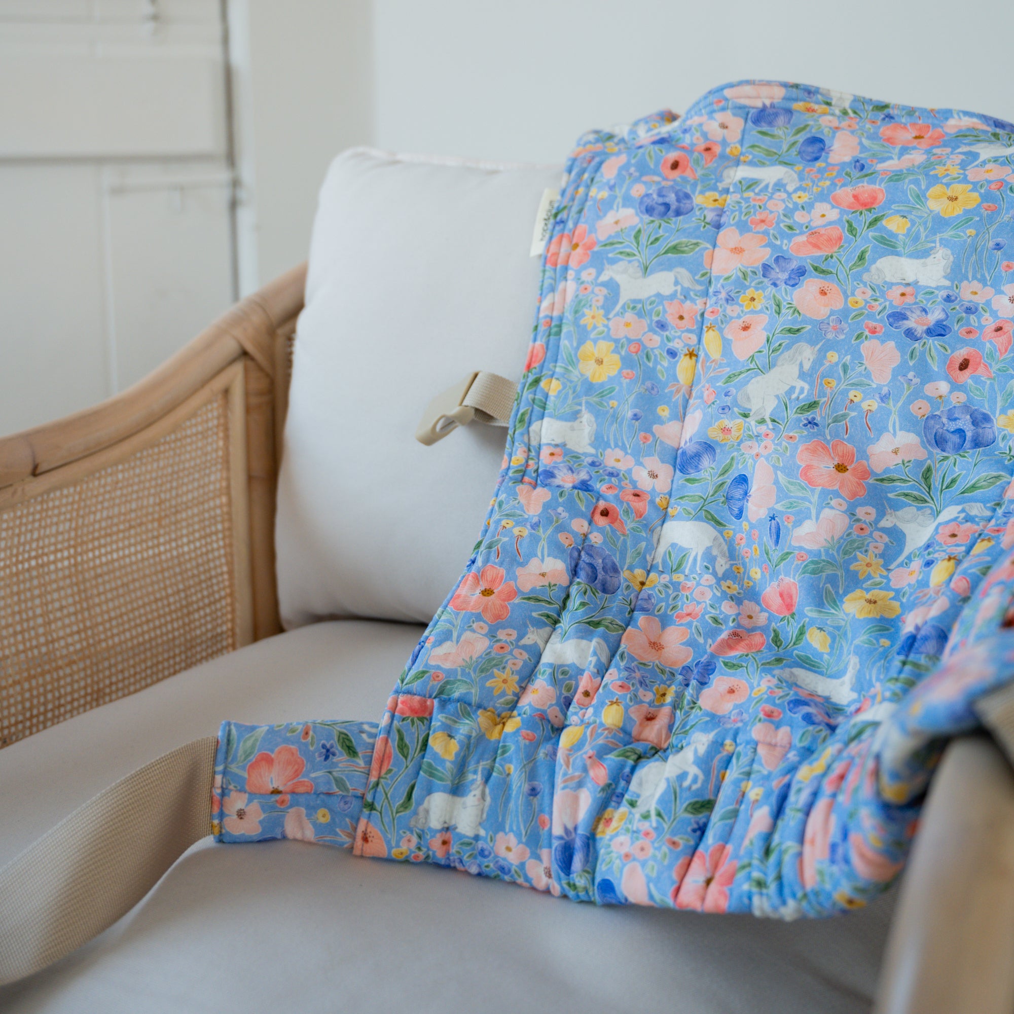 Floral-patterned baby carrier on a white chair