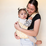 Latina mother wearing baby in floral print baby carrier. 