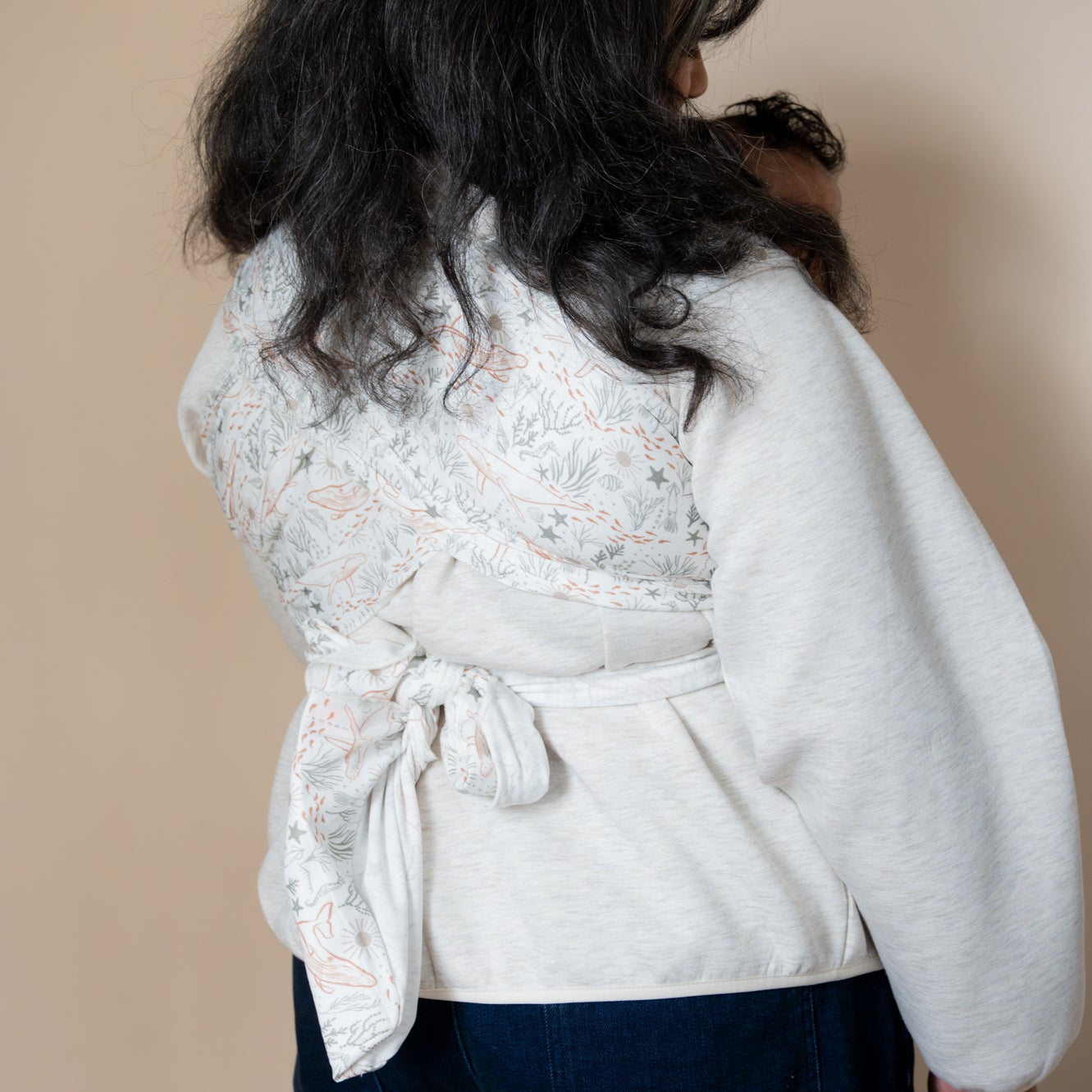 Woman holding a baby in a ocean print wrap