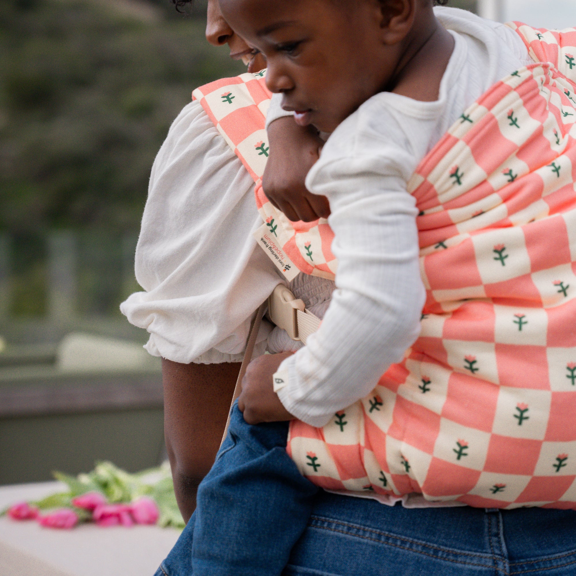 hope&plum Darling Kid Lark toddler carrier coral checkerboard with tulips in back carry position