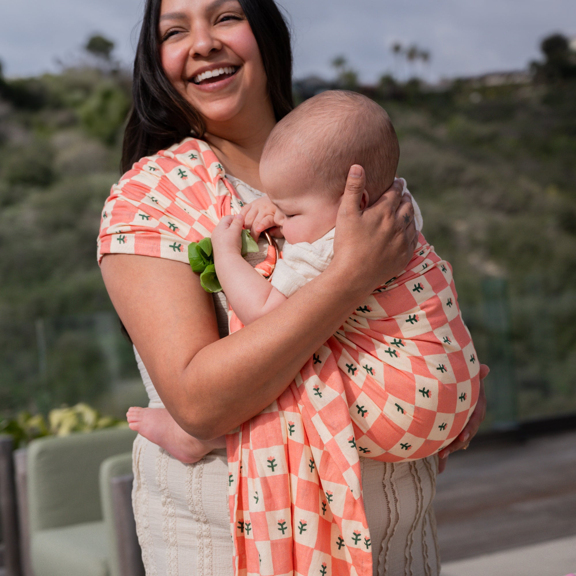 hope&plum Darling ring sling in coral checkerboard print worn front carry with newborn