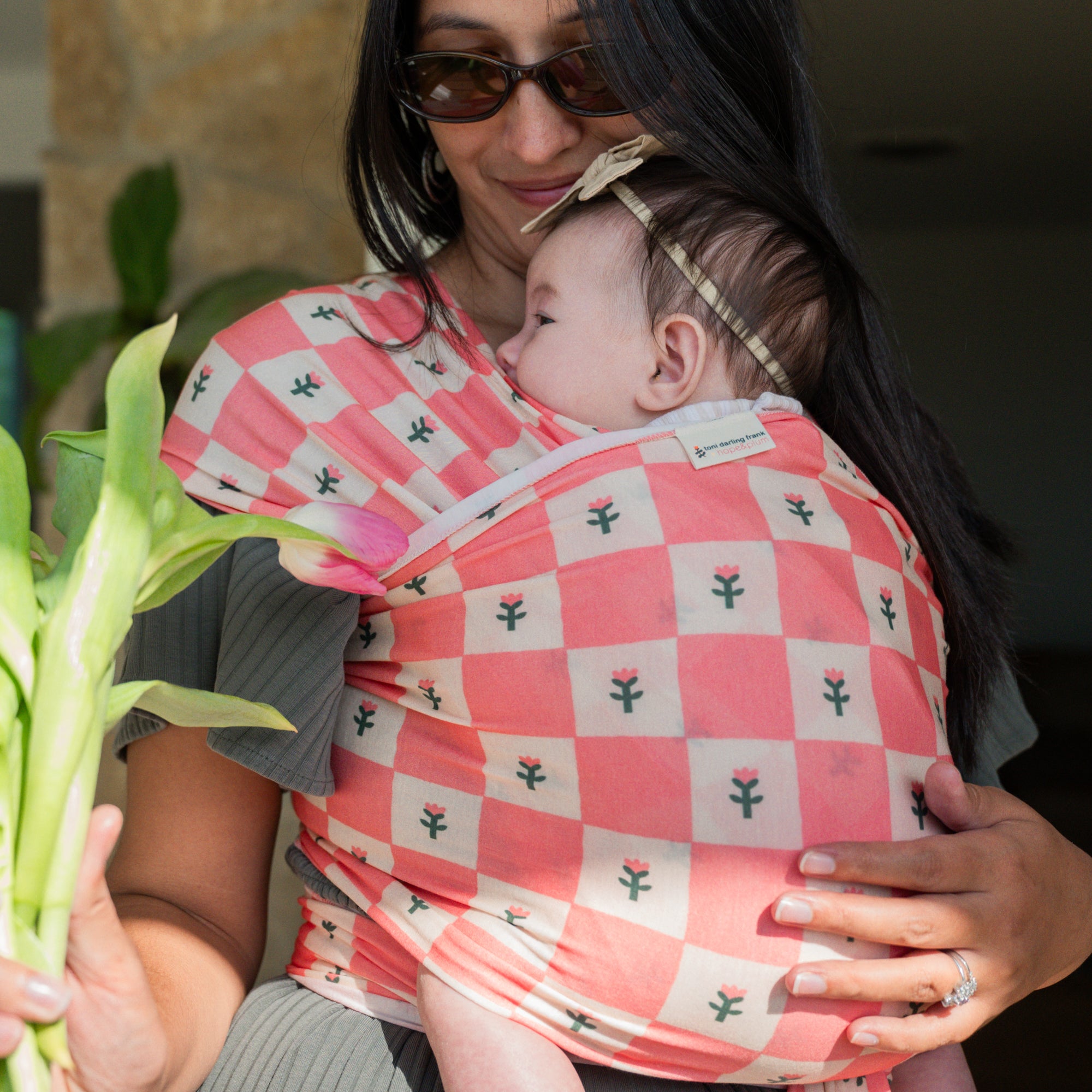 hope&plum Darling baby wrap carrier coral checkerboard with tulips in front carry position 
