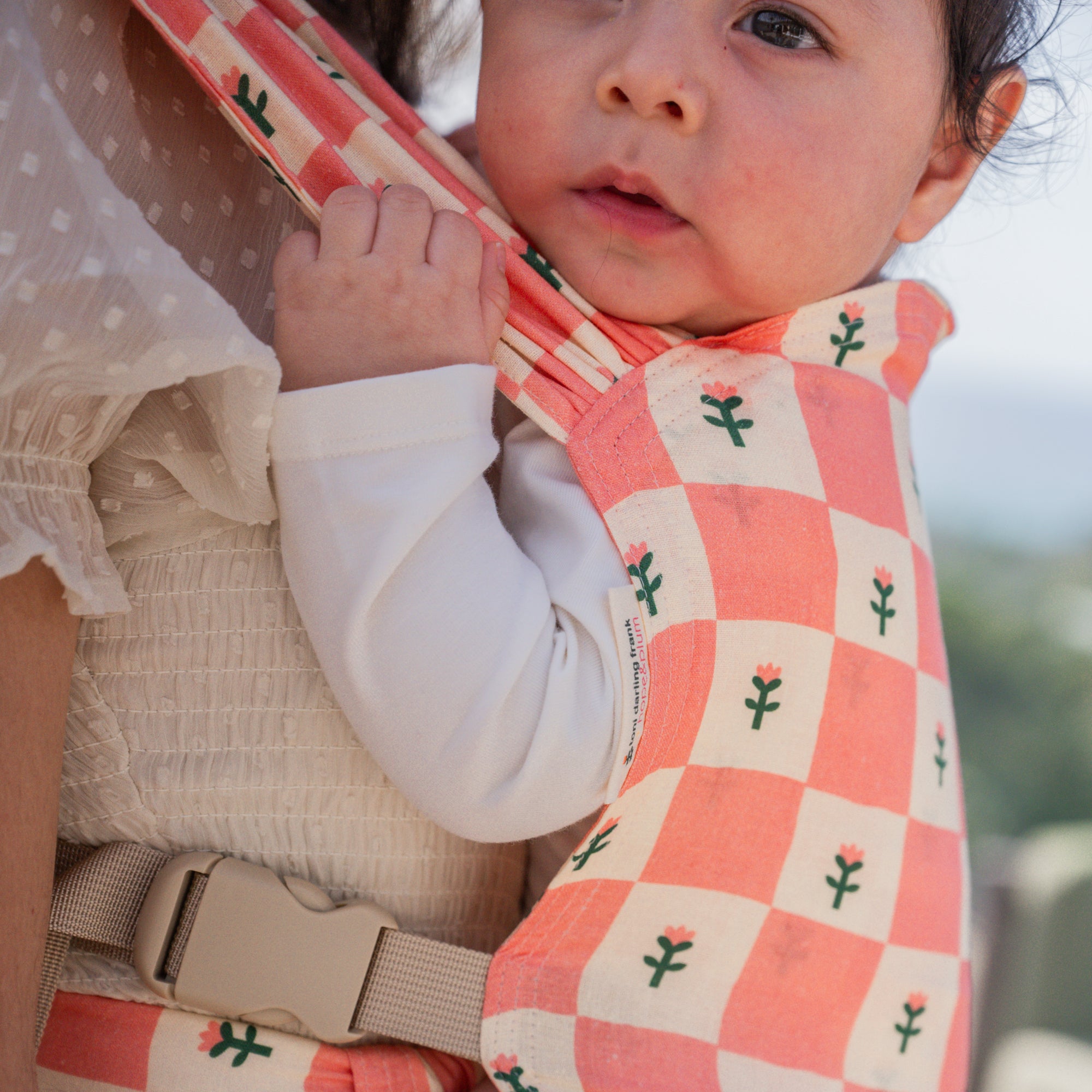 hope&plum Darling Sprout newborn buckle baby carrier coral checkerboard with tulips in front carry position 
