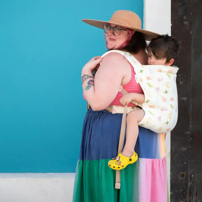 Parent wearing a hope&plum carrier