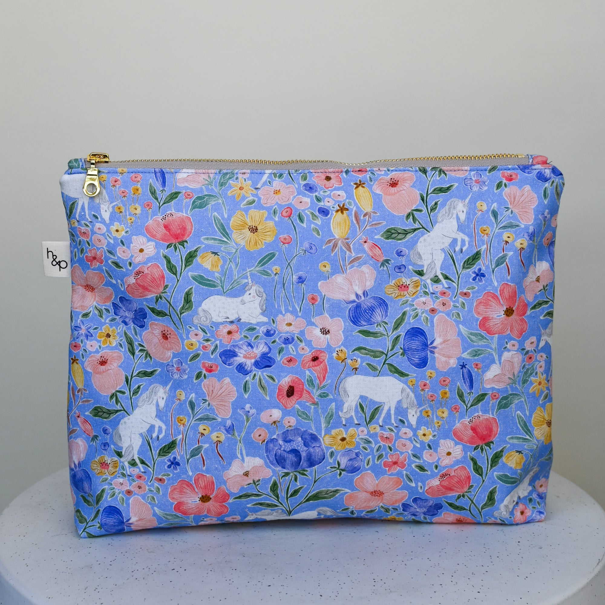 Floral and unicorn-patterned pouch on a white background