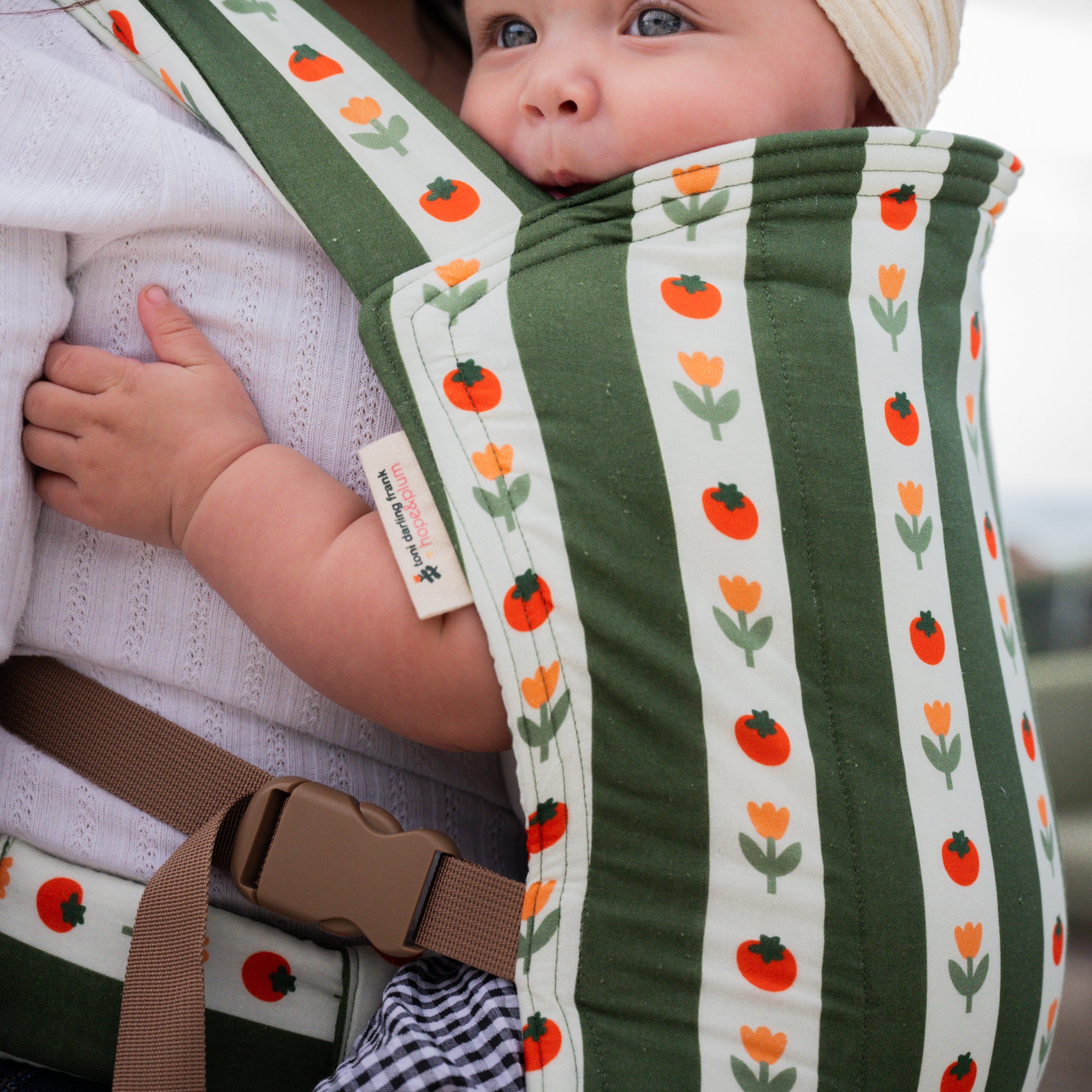 hope&plum Medley Lark buckle baby carrier olive green stripe with tomatoes and tulips in front carry position