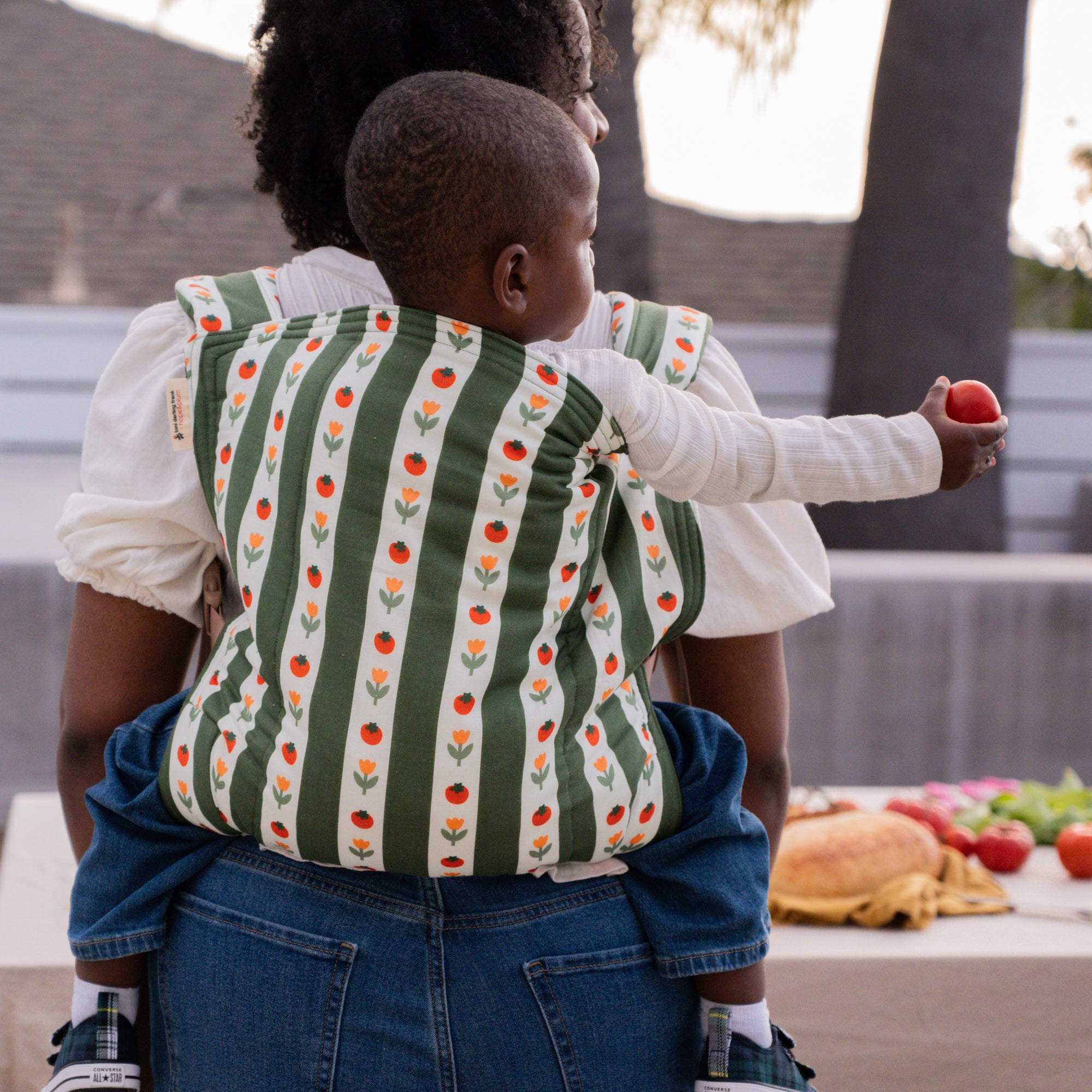 hope&plum Medley Kid Lark buckle toddler carrier olive green stripe with tomatoes and tulips in back carry position