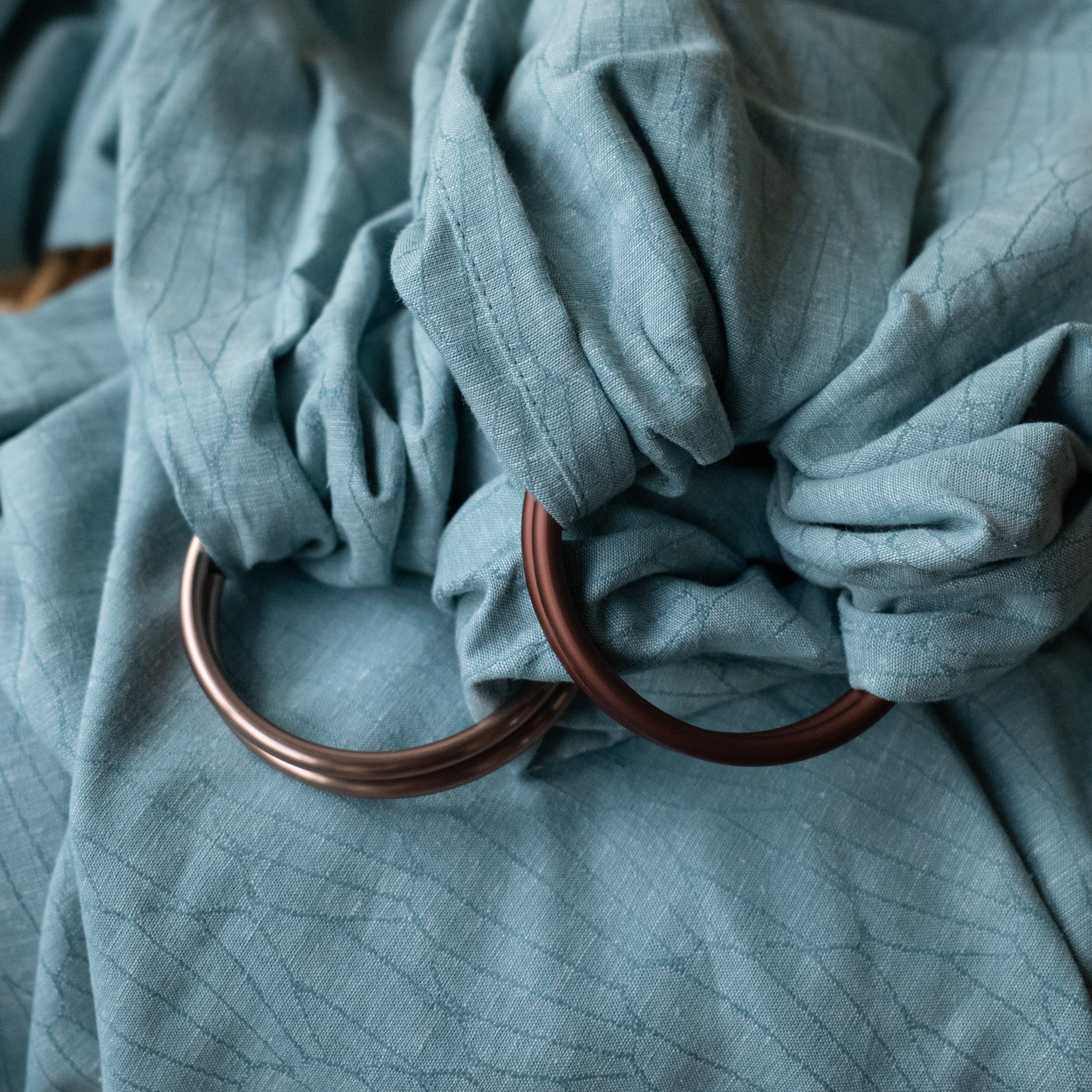 blue seashell woven patterned ring slings one with champagne rings and one with bronze rings 